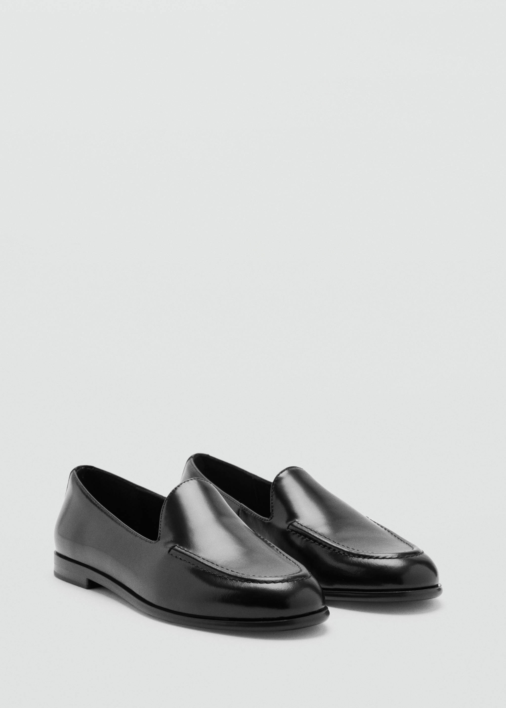 Mocasines planos de piel negros en vista de tres cuartos.