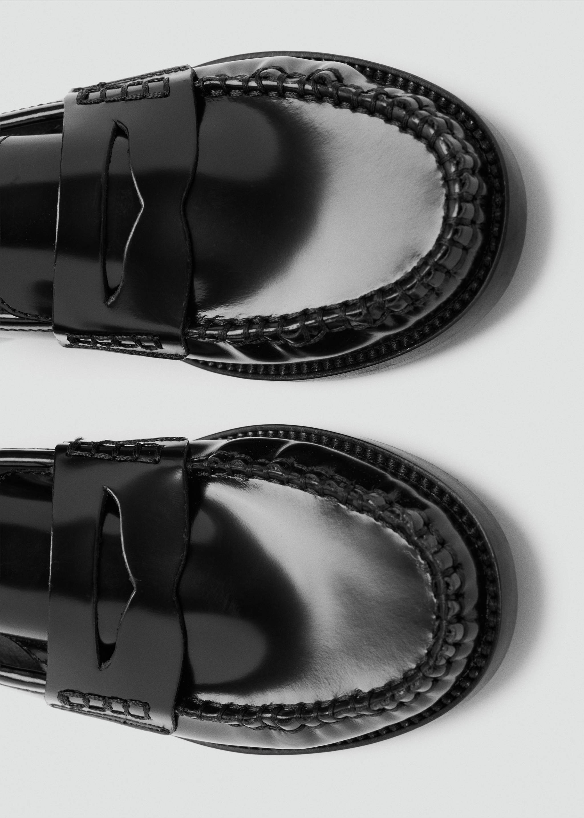 Close-up of black patent leather loafers with classic penny strap., Black. Ref: 47011348-00.