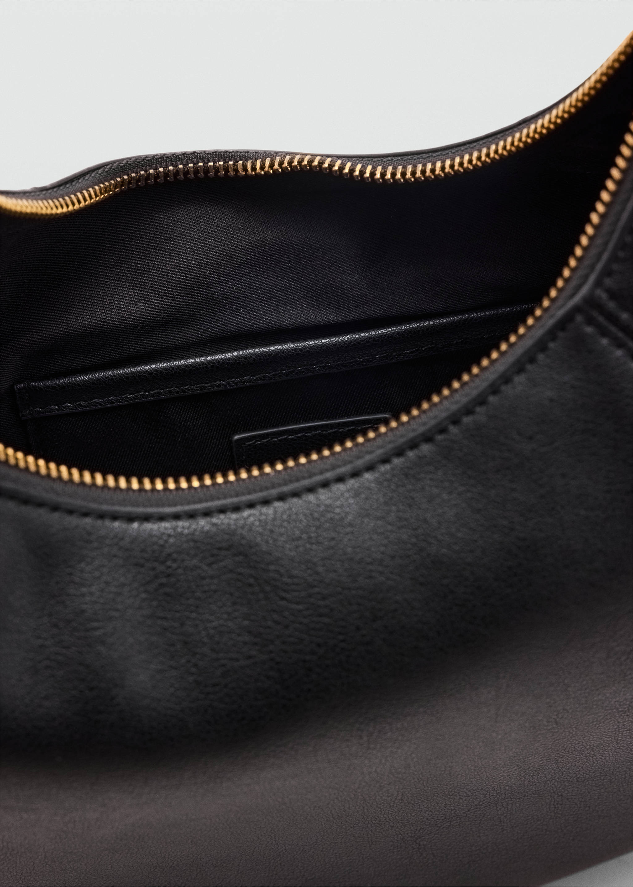Close-up of a black shoulder bag interior with a zip closure., Black. Ref: 47011355-00.