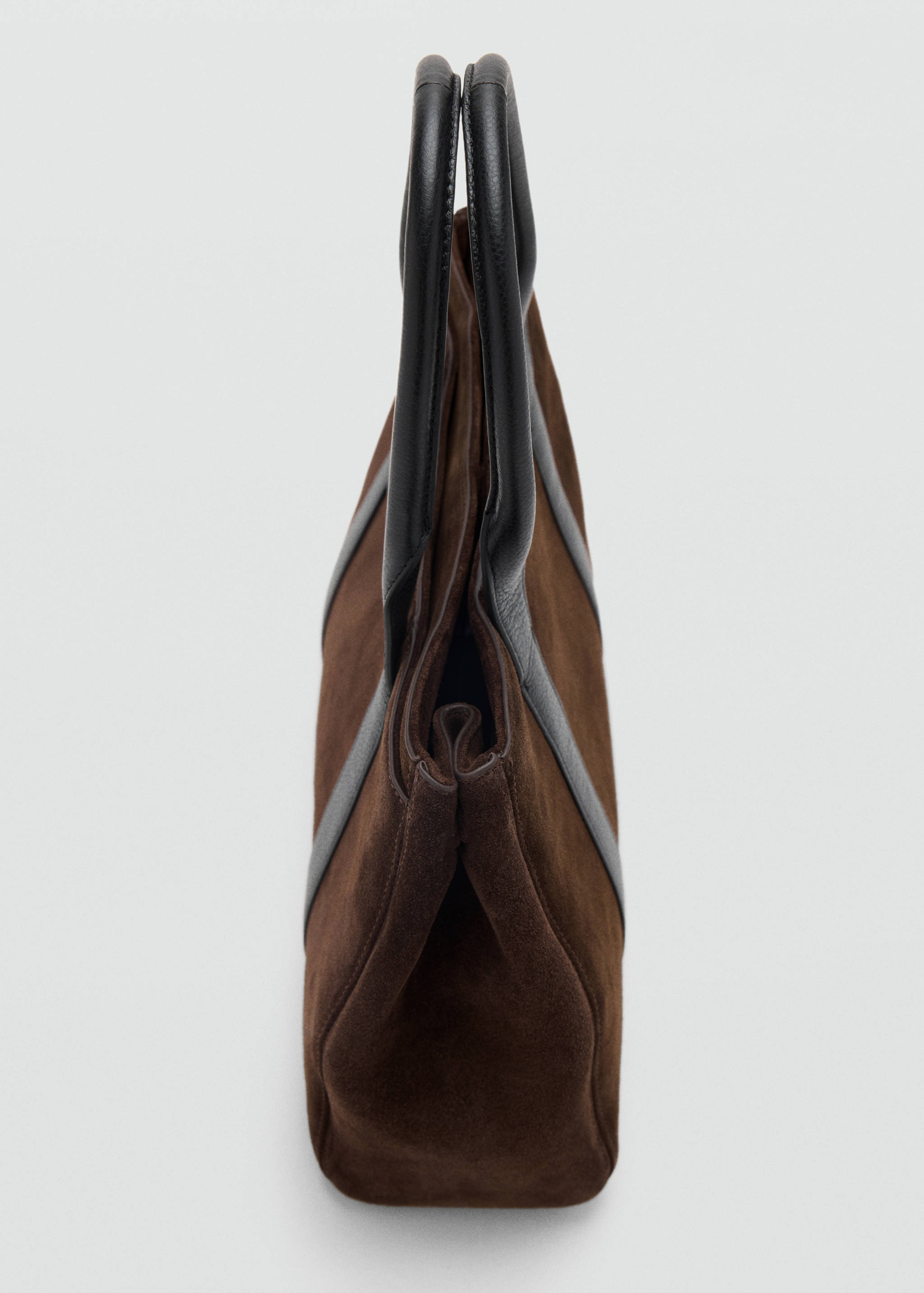 Brown city bag in suede with dark leather trim and top handles, side view.