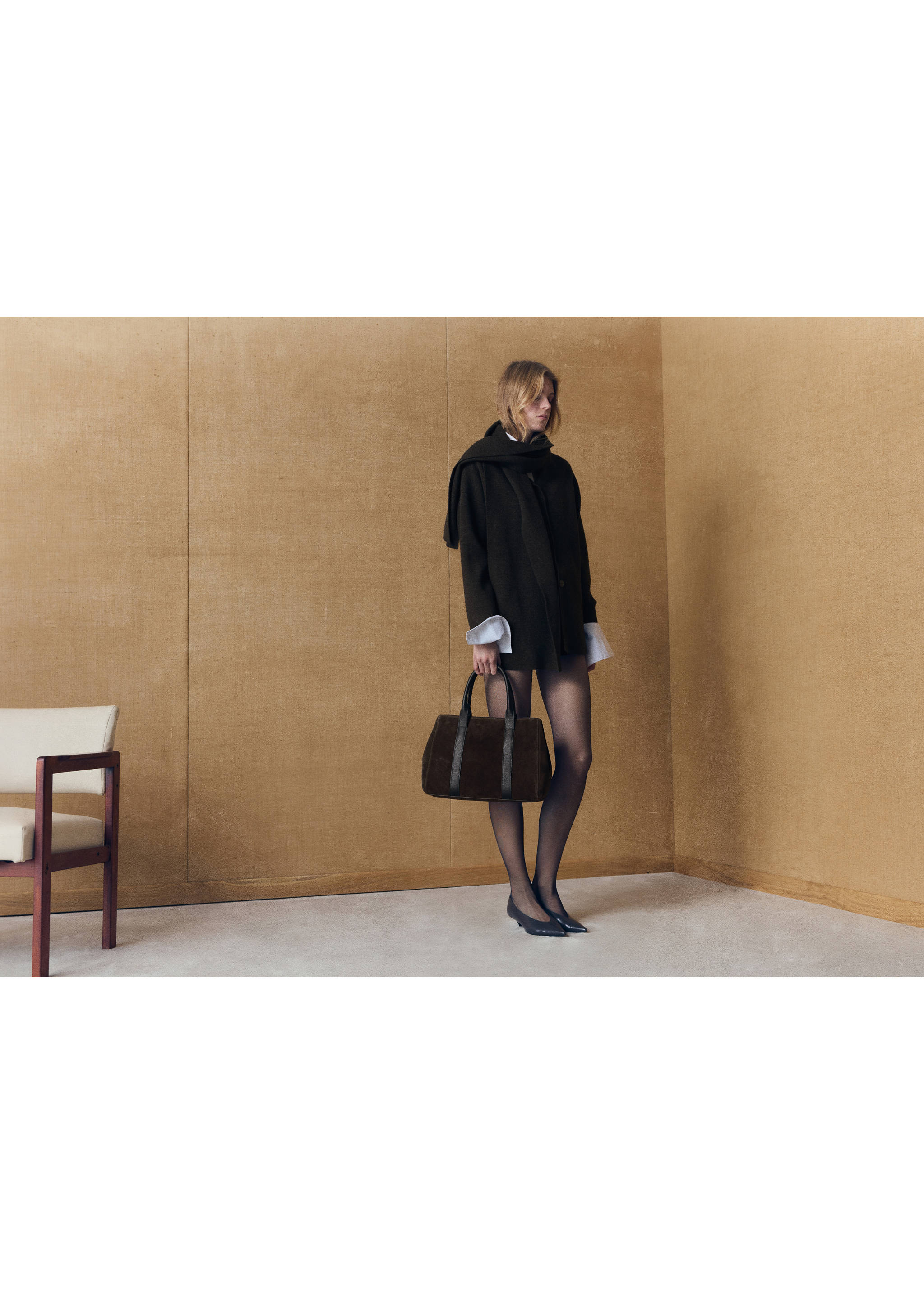 Dark brown city bag with twin top handles, held by a model., Chocolate. Ref: 47011357-00.