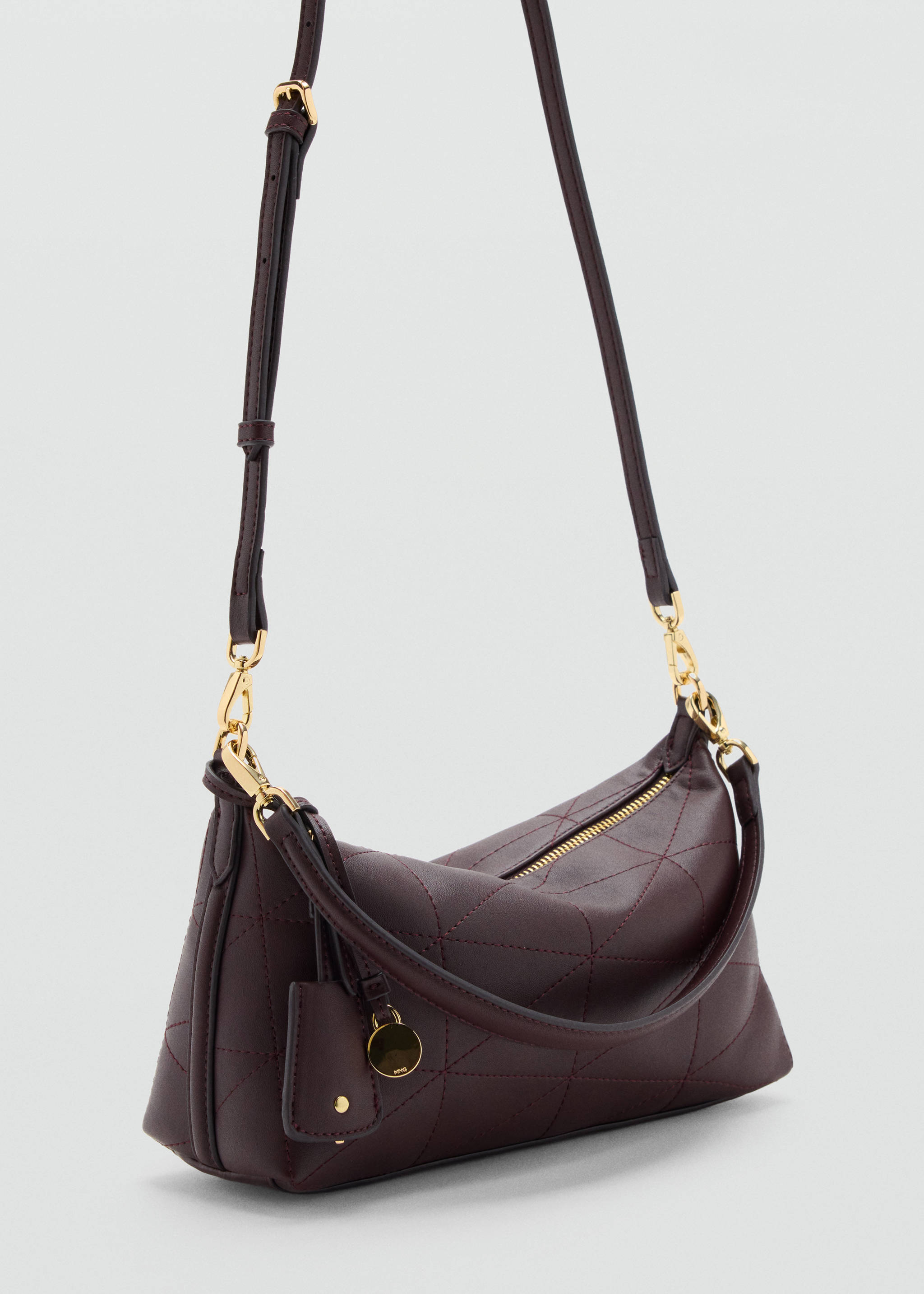 Bolso bandolera acolchado en color burdeos con detalles metálicos dorados.
