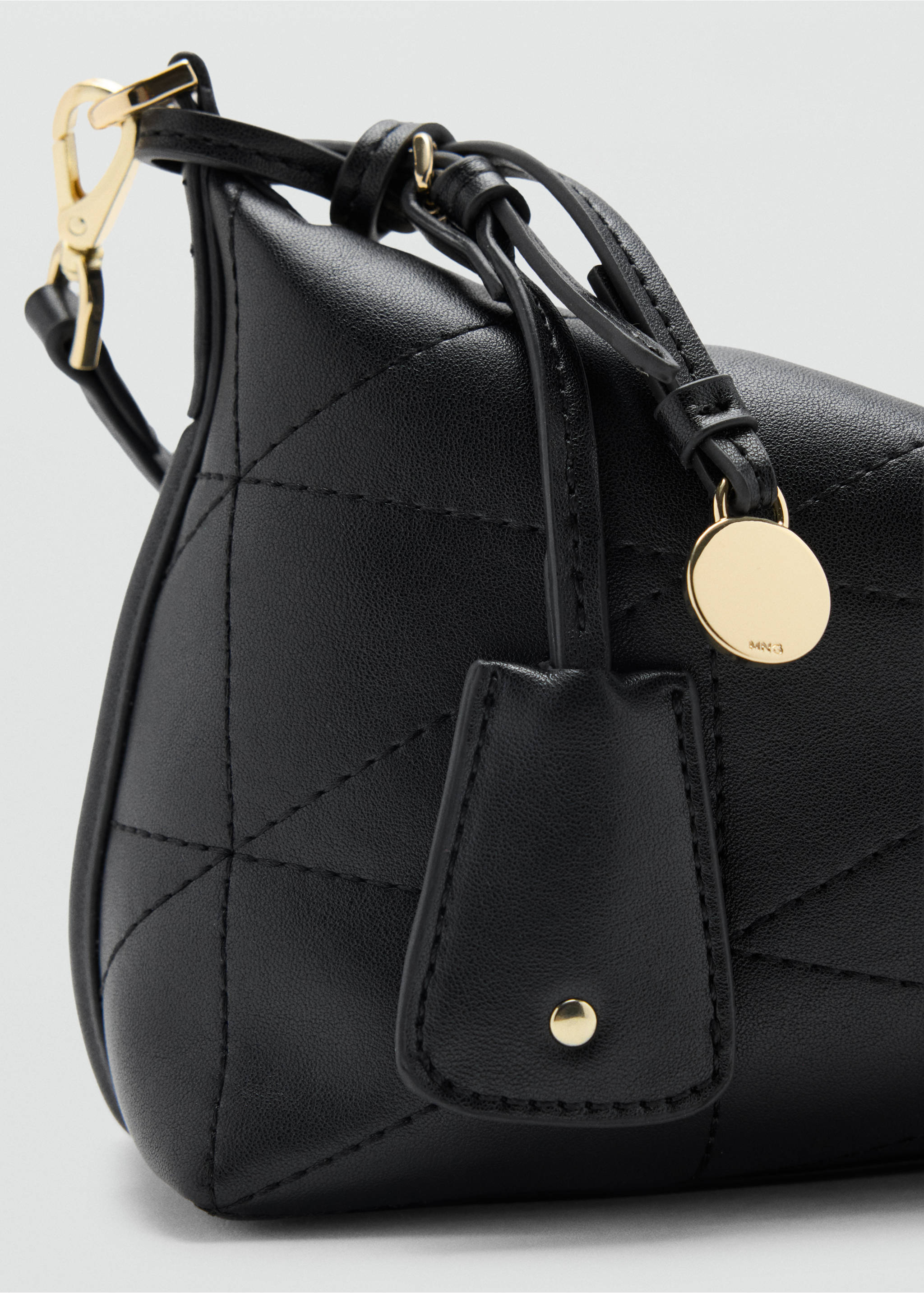 Primer plano de un bolso bandolera acolchado de color negro con herrajes dorados., Negro. Ref: 47011358-00.
