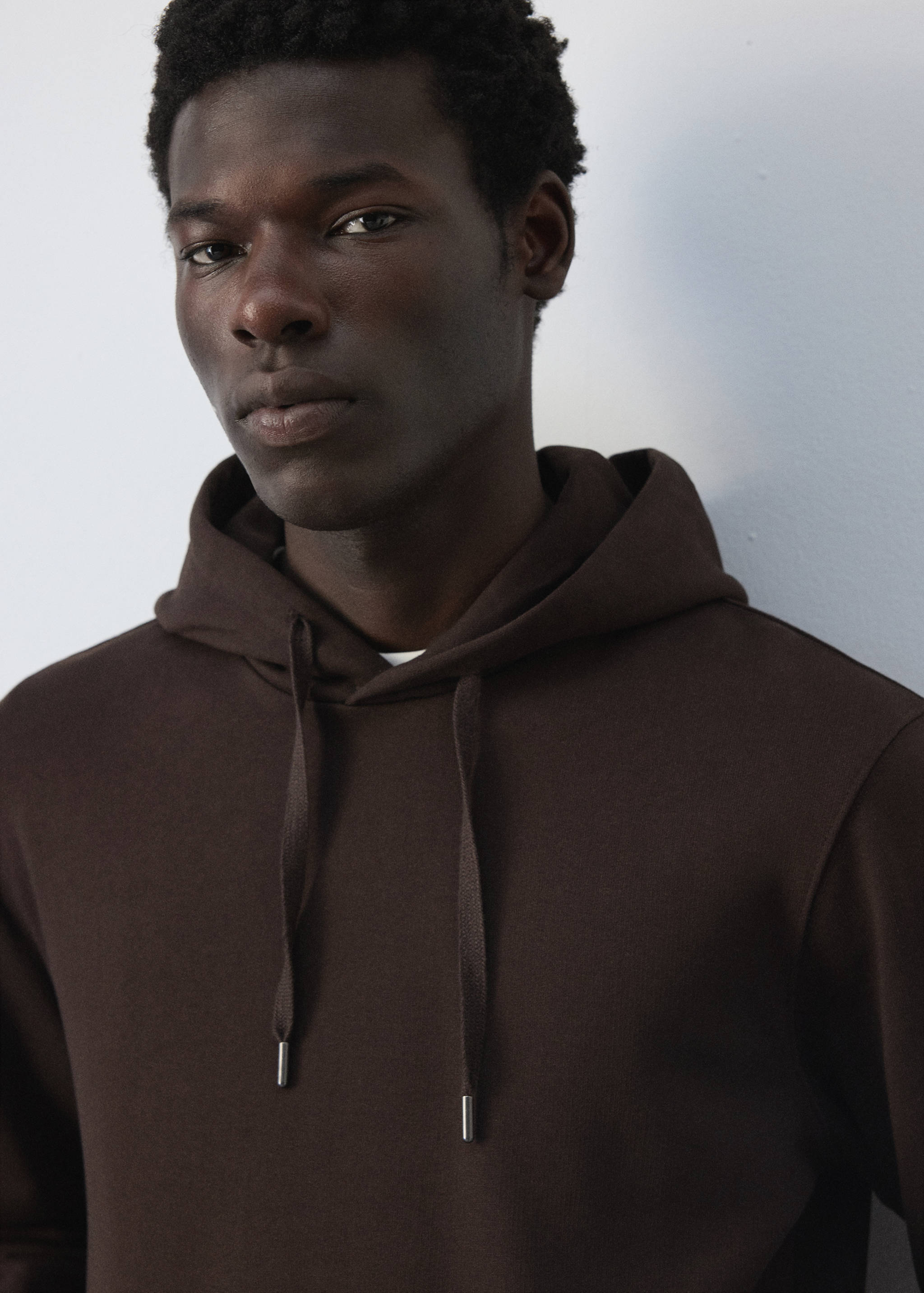 Close-up of a dark brown hoodie with a drawstring hood.