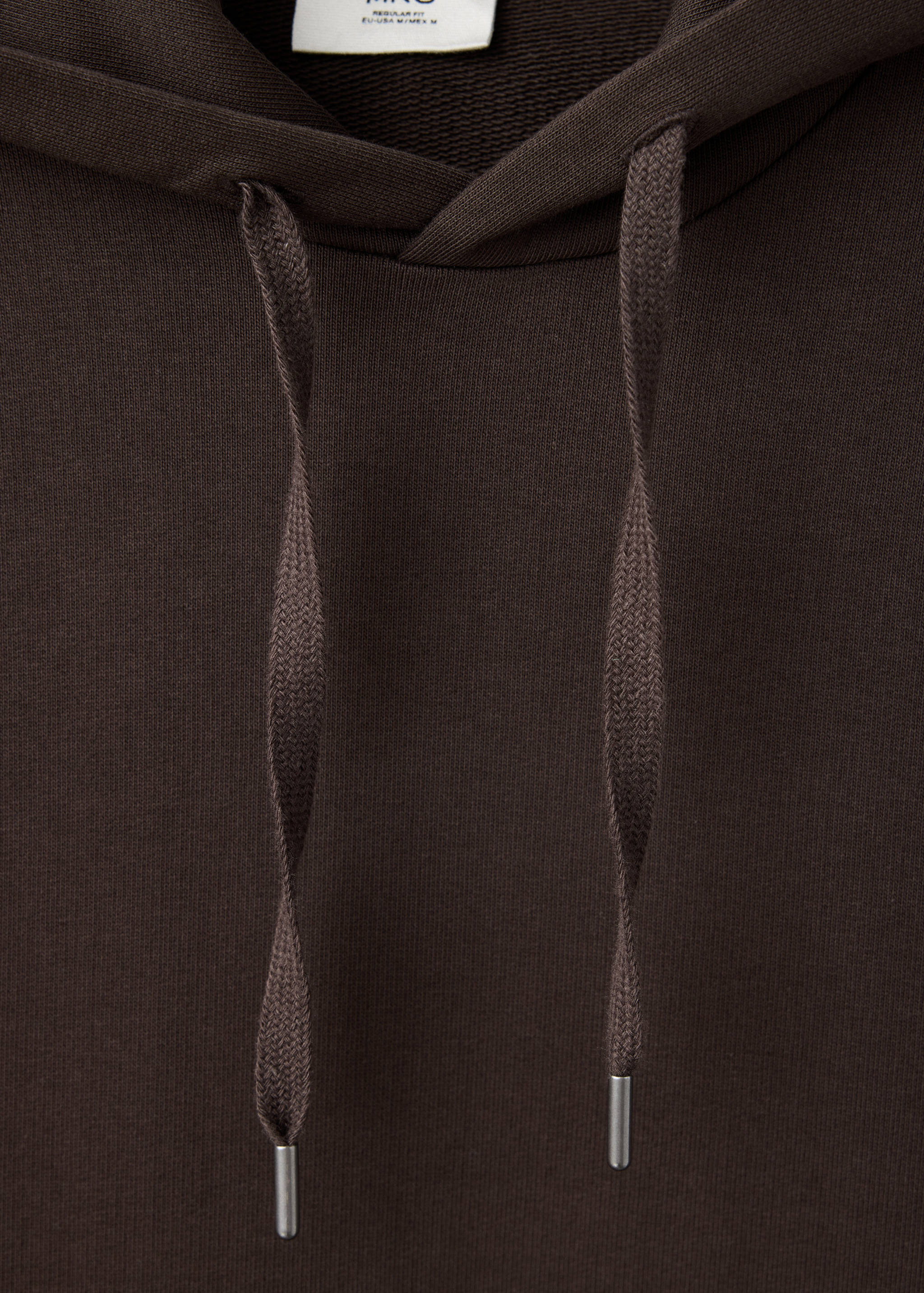 Close-up of a dark brown hoodie with matching drawstrings and silver aglets.