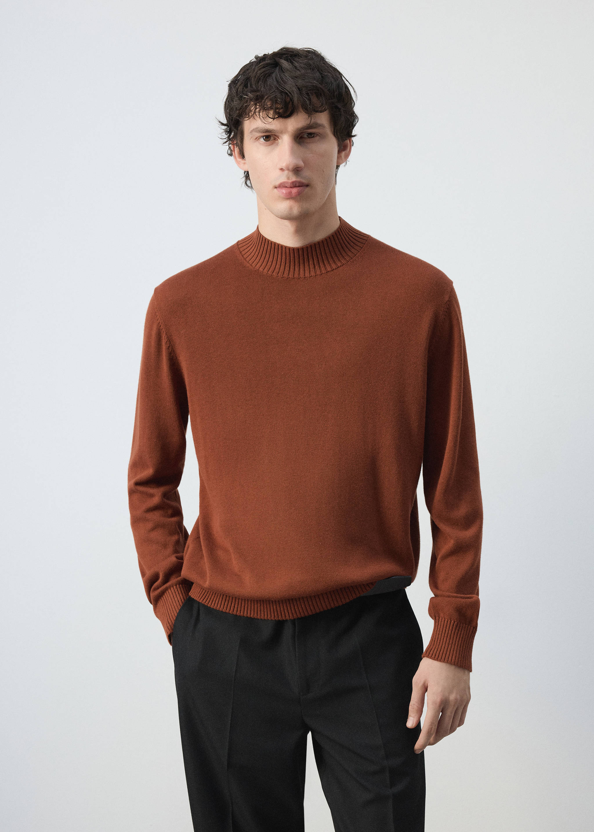 Rust-brown knitted jersey with a ribbed mock neck, cuffs, and hem.