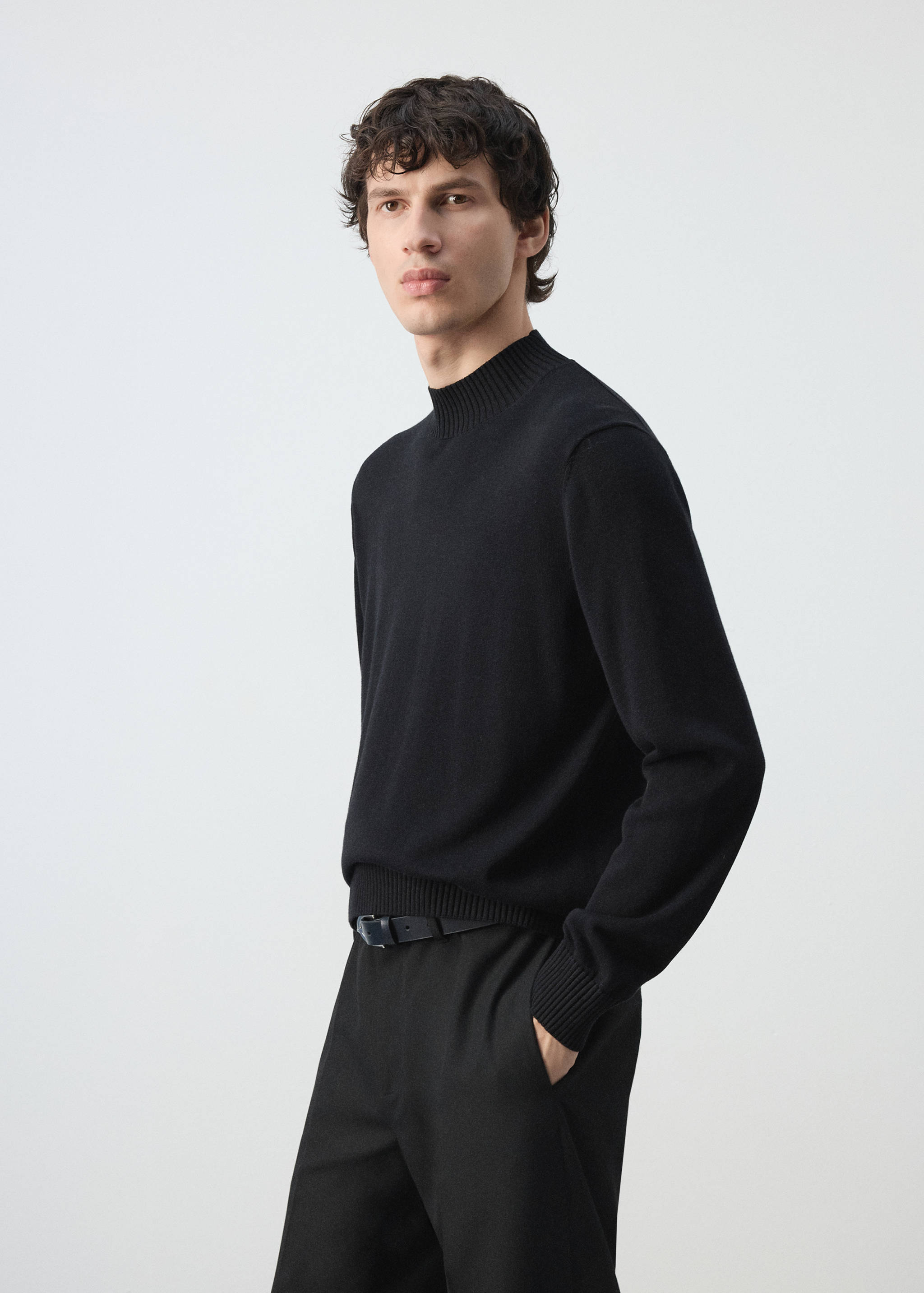 Black long-sleeved jersey with a ribbed high neck, cuffs, and hem.