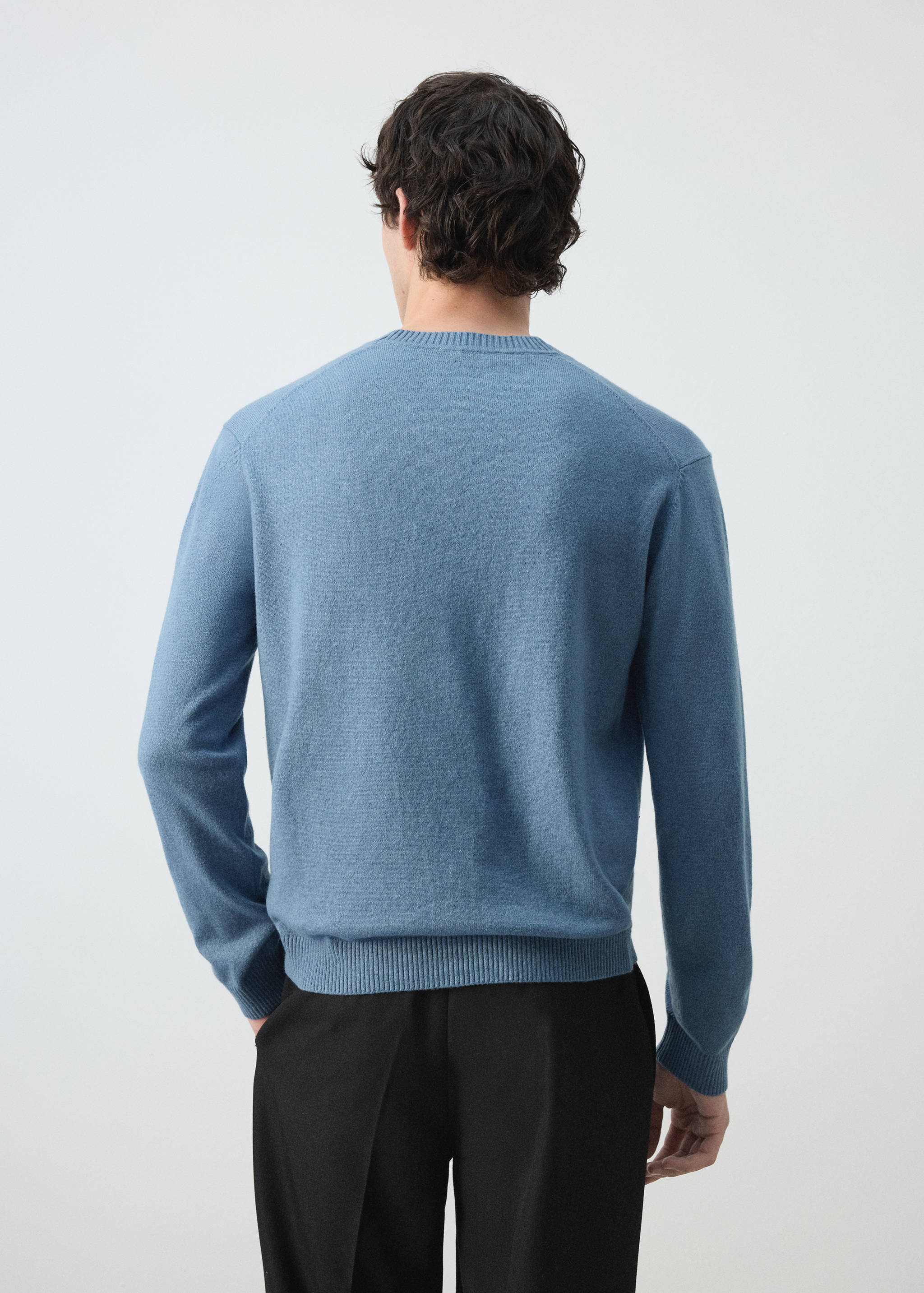 Vista trasera de un jersey de punto azul claro con cuello redondo canalé.