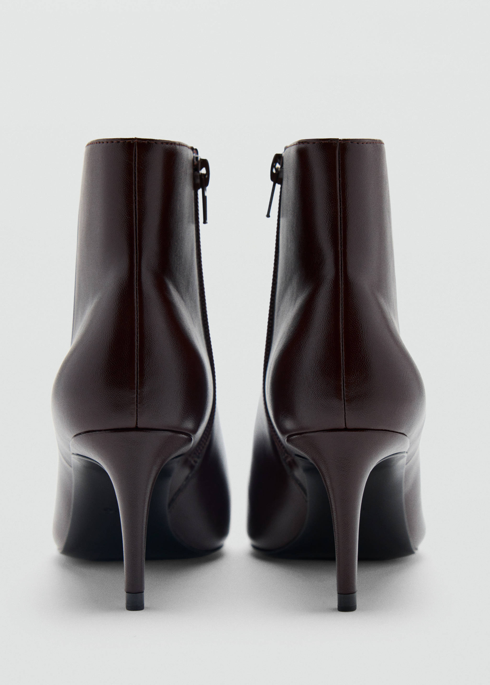 Botines de caña baja en marrón oscuro con tacón de aguja y vista trasera.