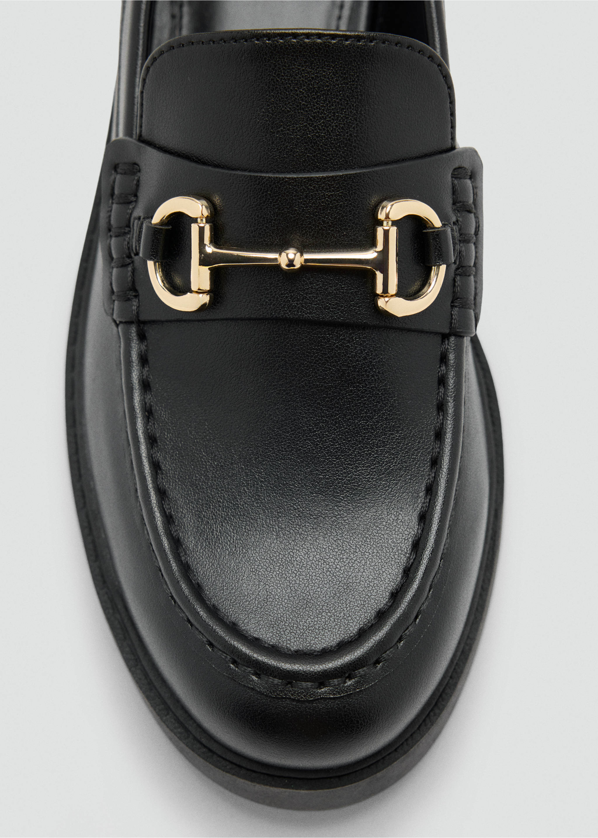 Primer plano de un mocasín negro con detalle de hebilla metálica dorada., Negro. Ref: 47021340-00.