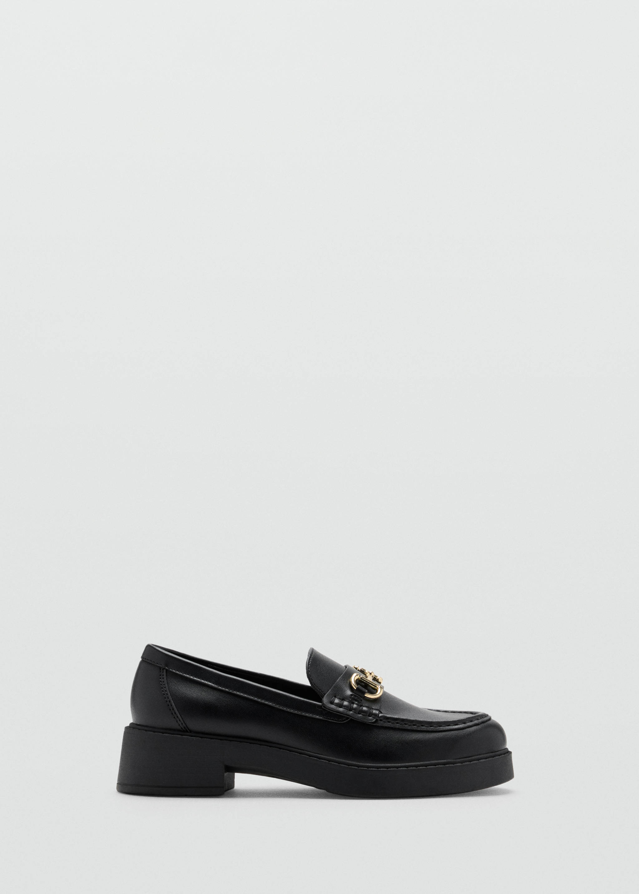 Mocasín de piel negro con suela track y detalle de estribo metálico dorado.