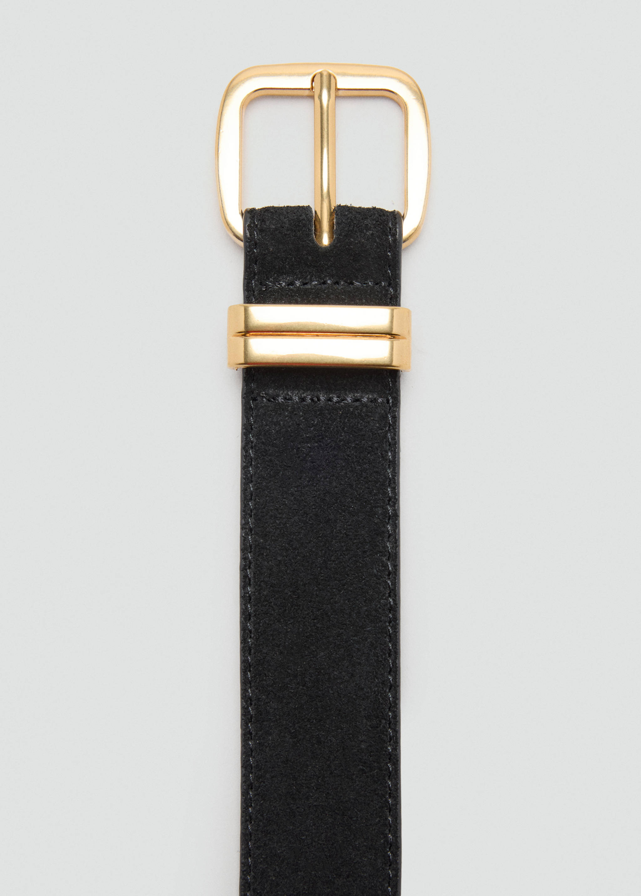 Close-up of a black suede belt with a polished gold buckle.