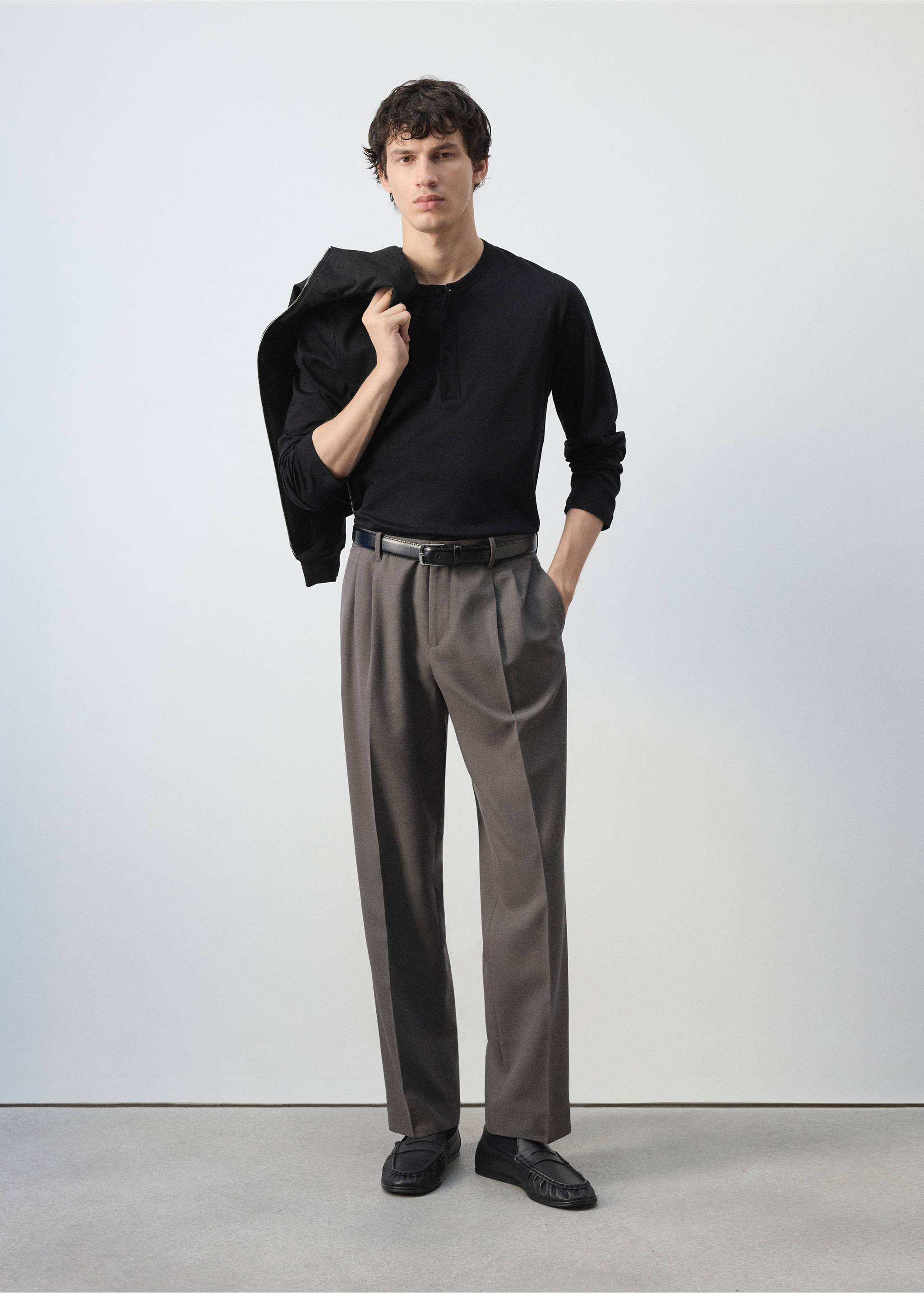 Grey pleated trousers worn with a black long-sleeved top and belt, Medium Brown. Ref: 47031324-00.