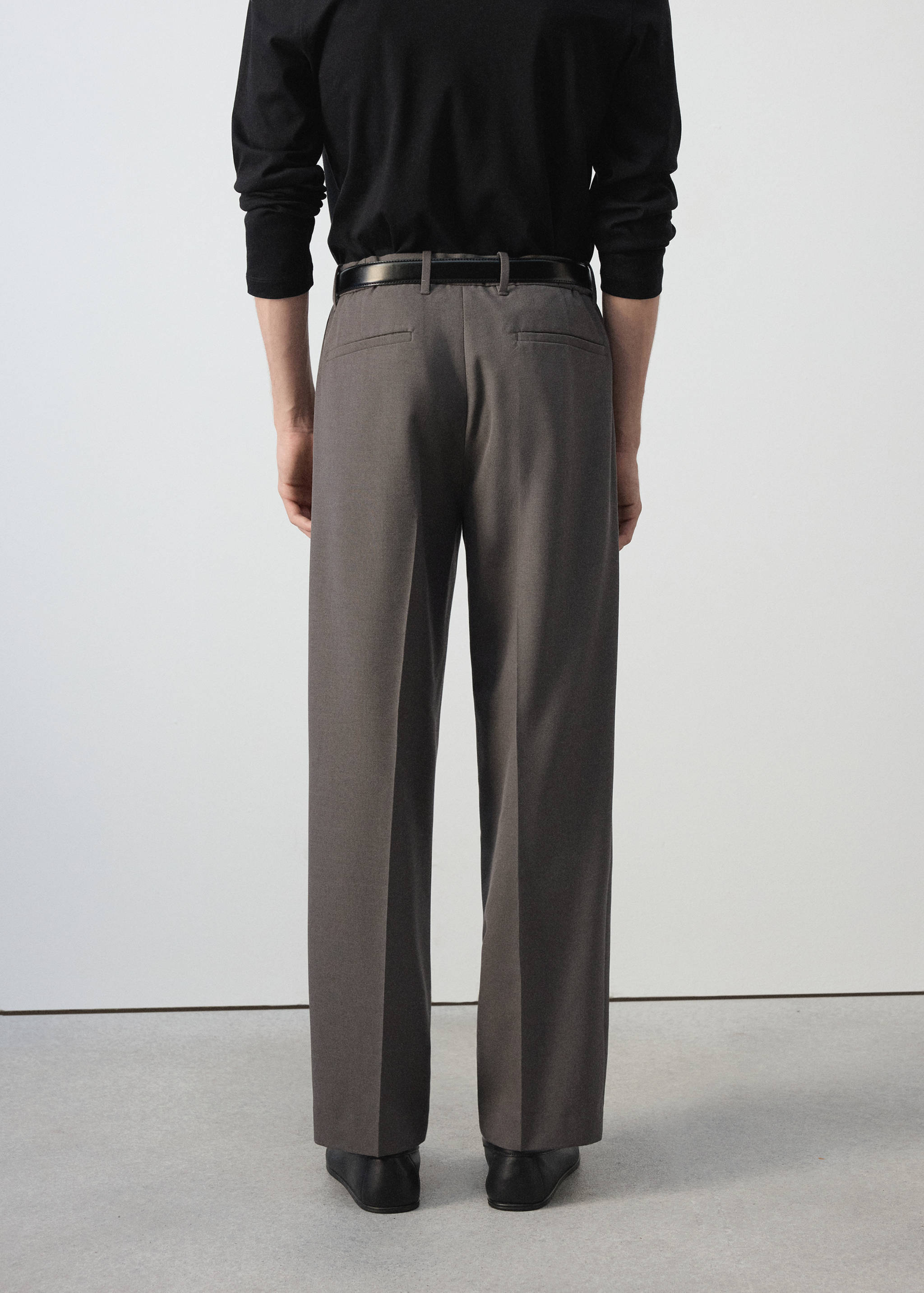 Dark grey trousers with straight legs and back welt pockets, back view.