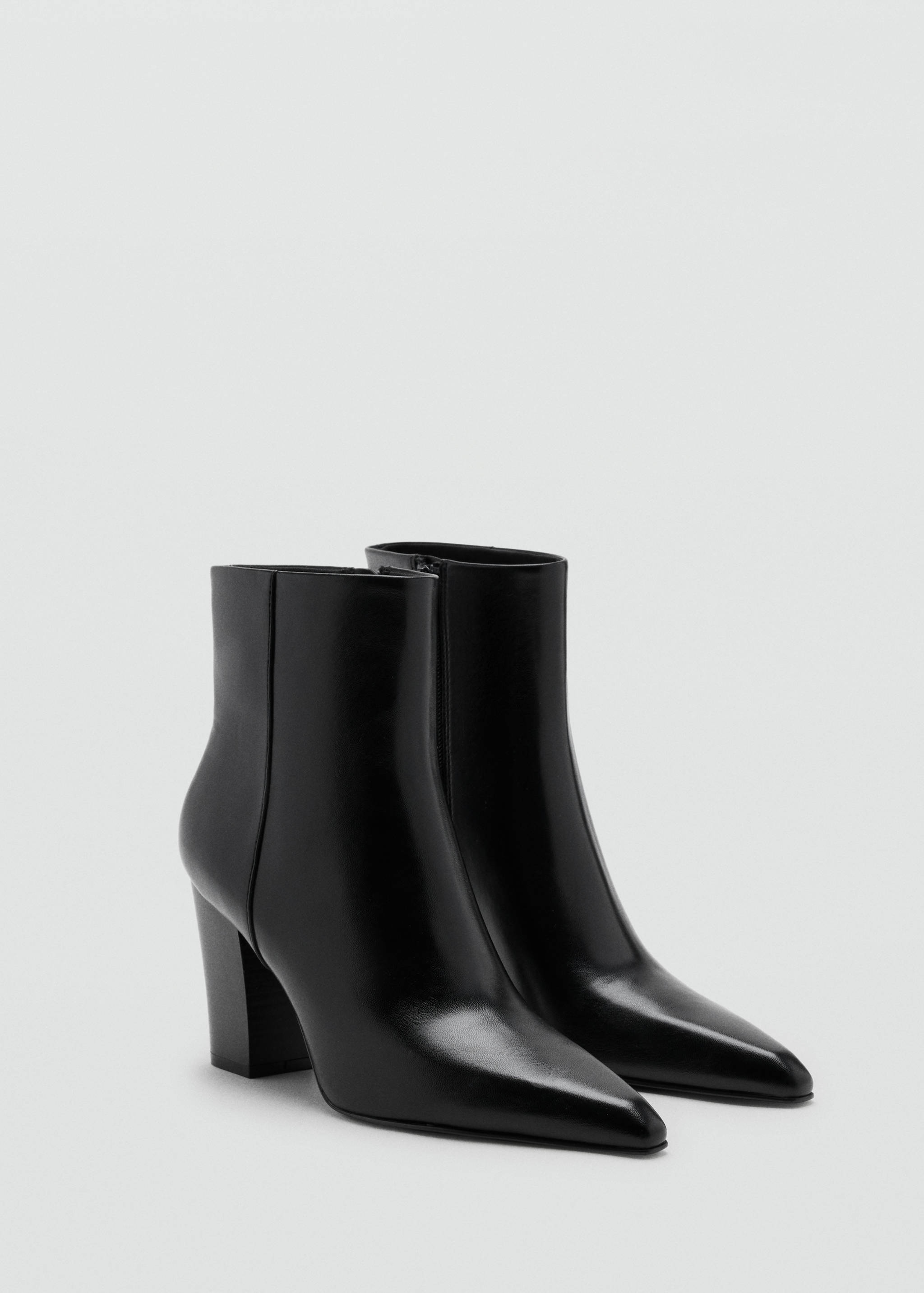 Black ankle boots with a pointed toe and block heel in a three-quarter view.