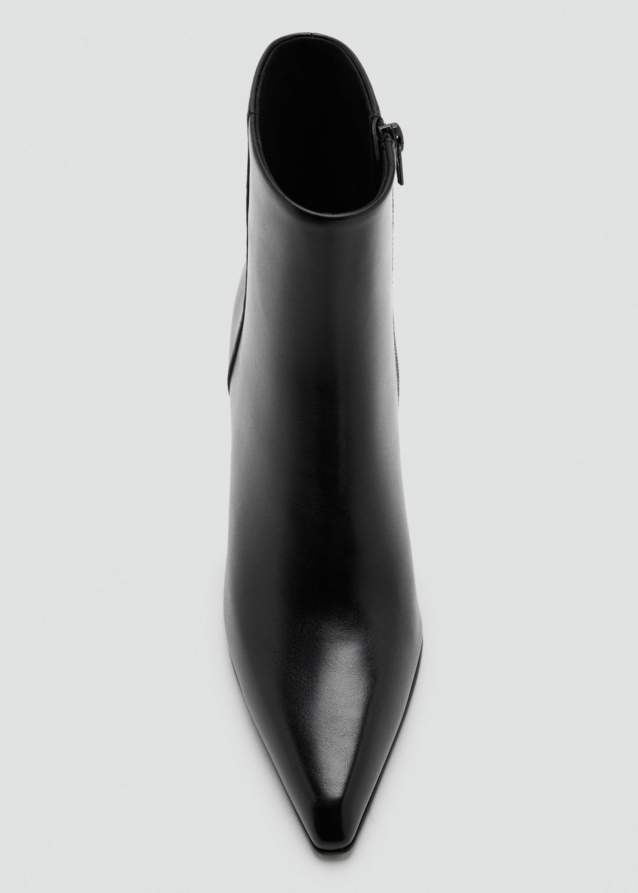 Black ankle boot with a pointed toe and side zipper in a close-up view.