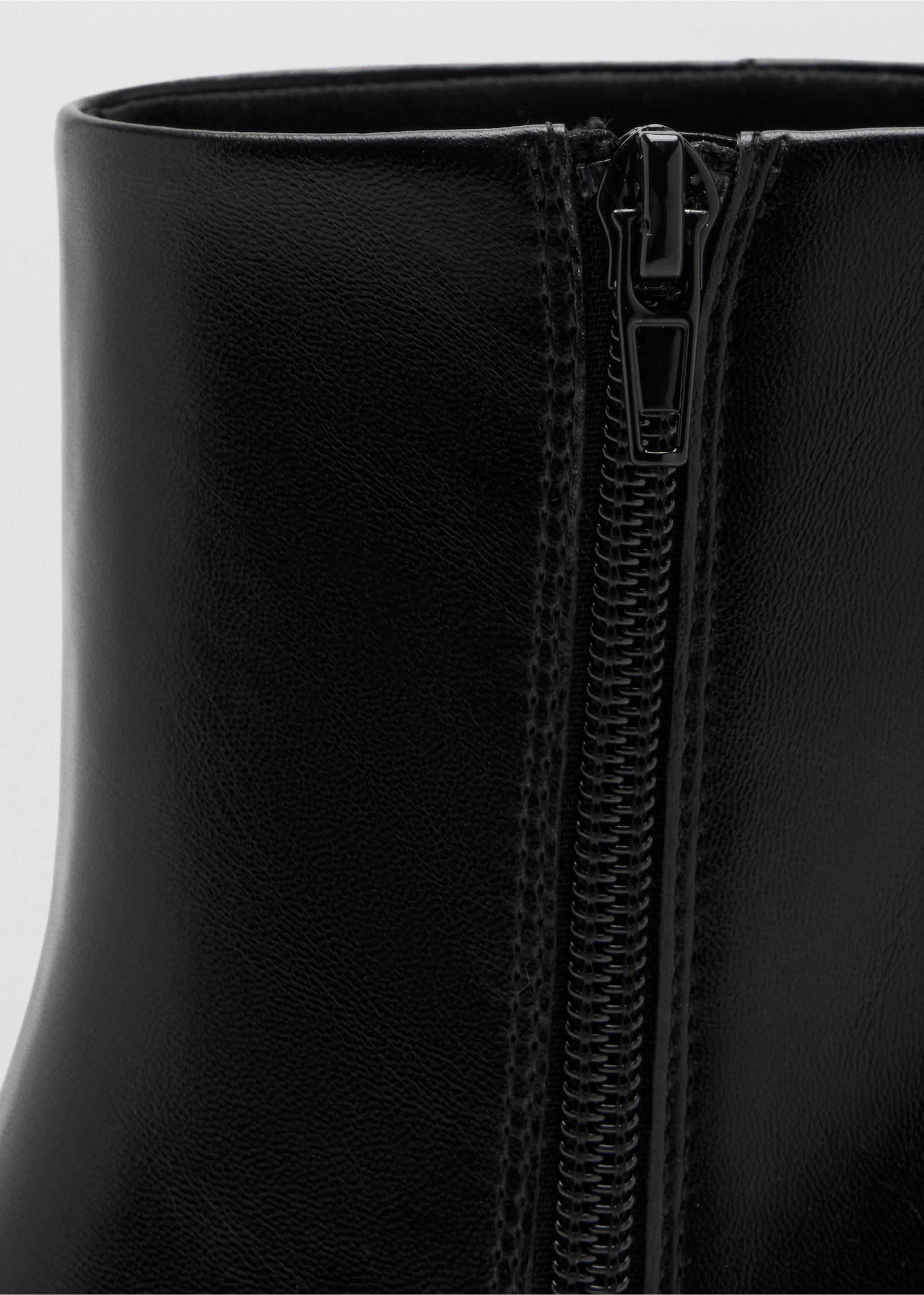 Close-up of the side zip detail on a black leather ankle boot., Black. Ref: 47031338-00.