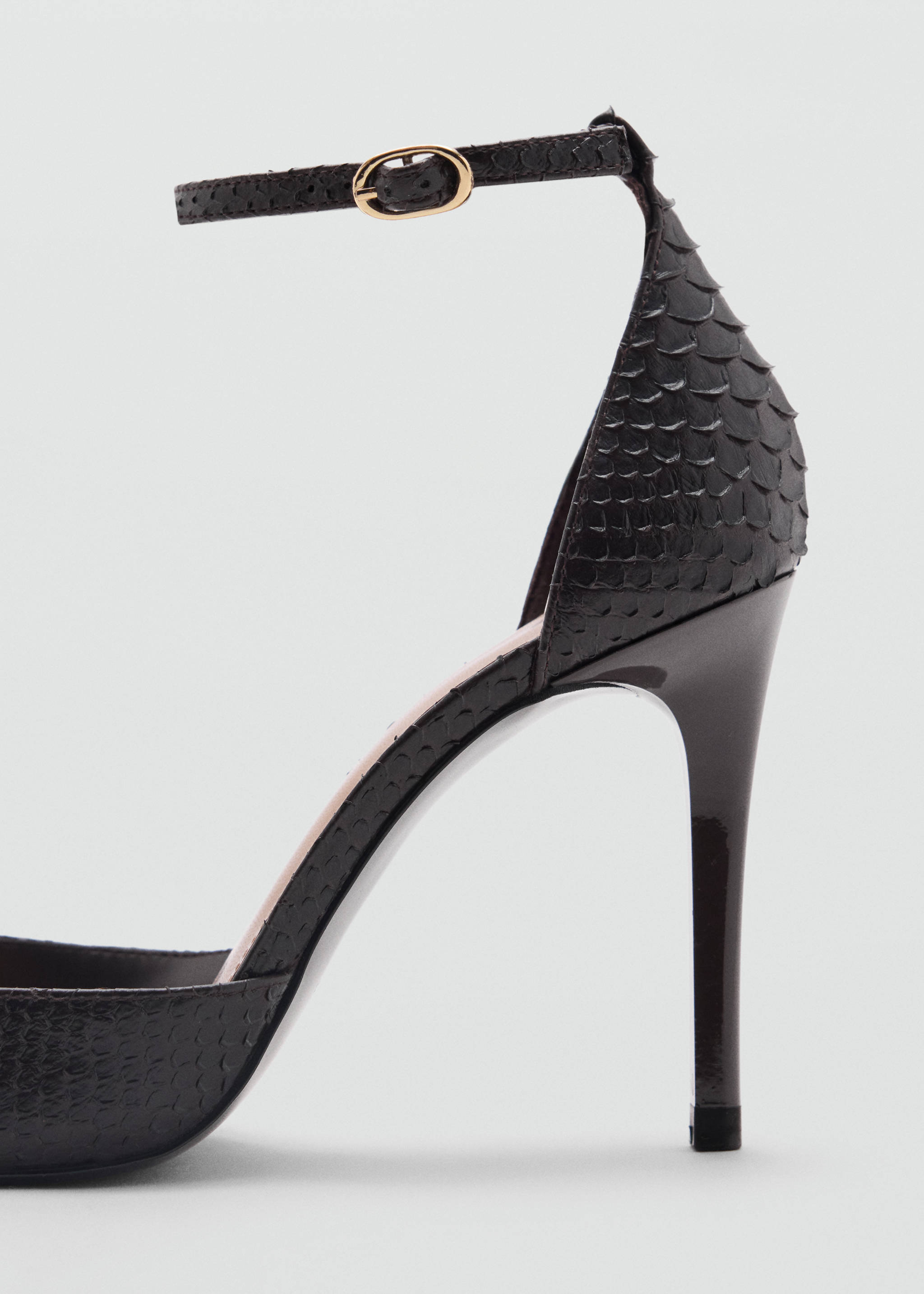 Close-up of a dark brown snakeskin-effect shoe heel and ankle strap.
