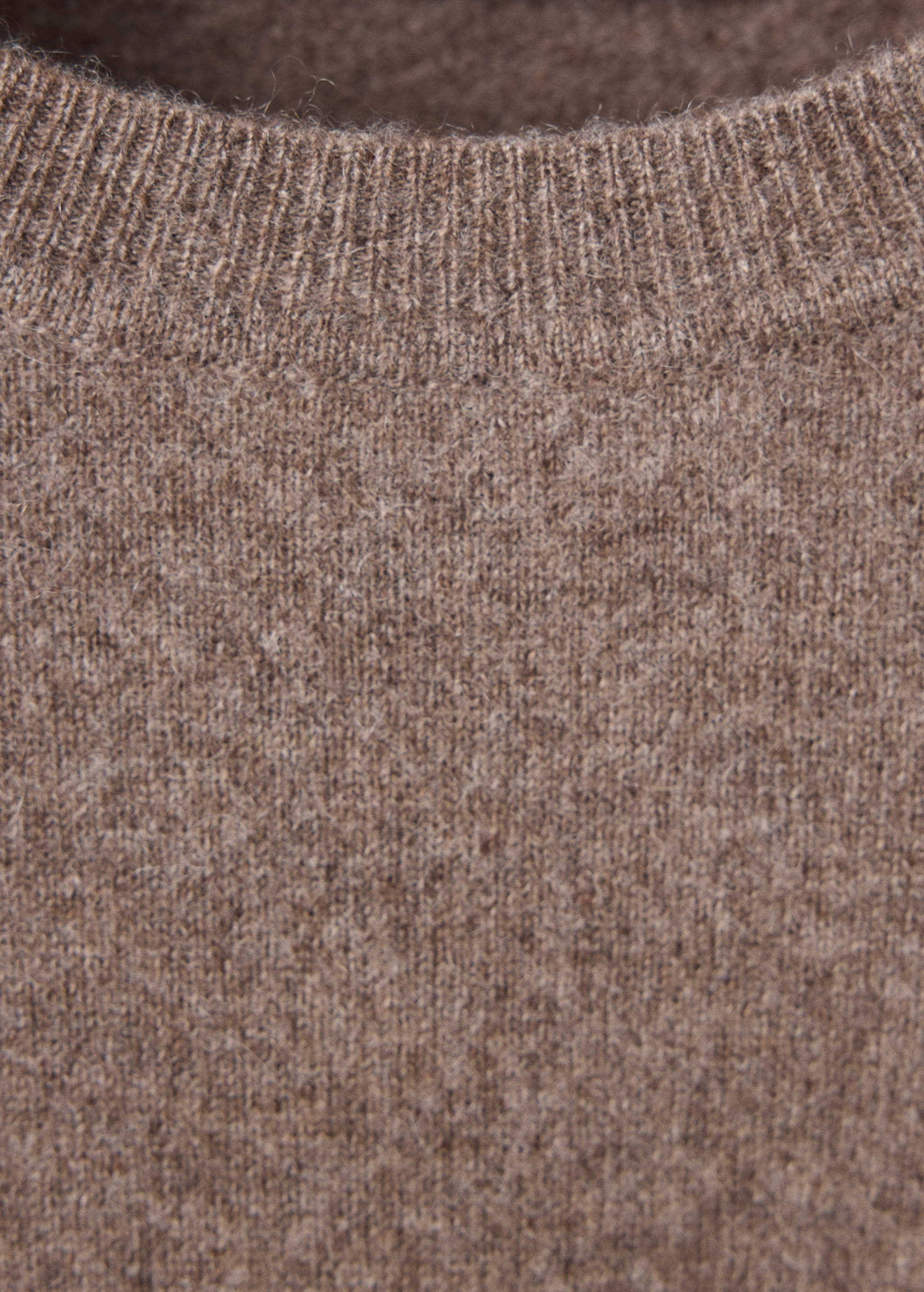 Close-up of a brown knit jersey showing its ribbed crew neckline.