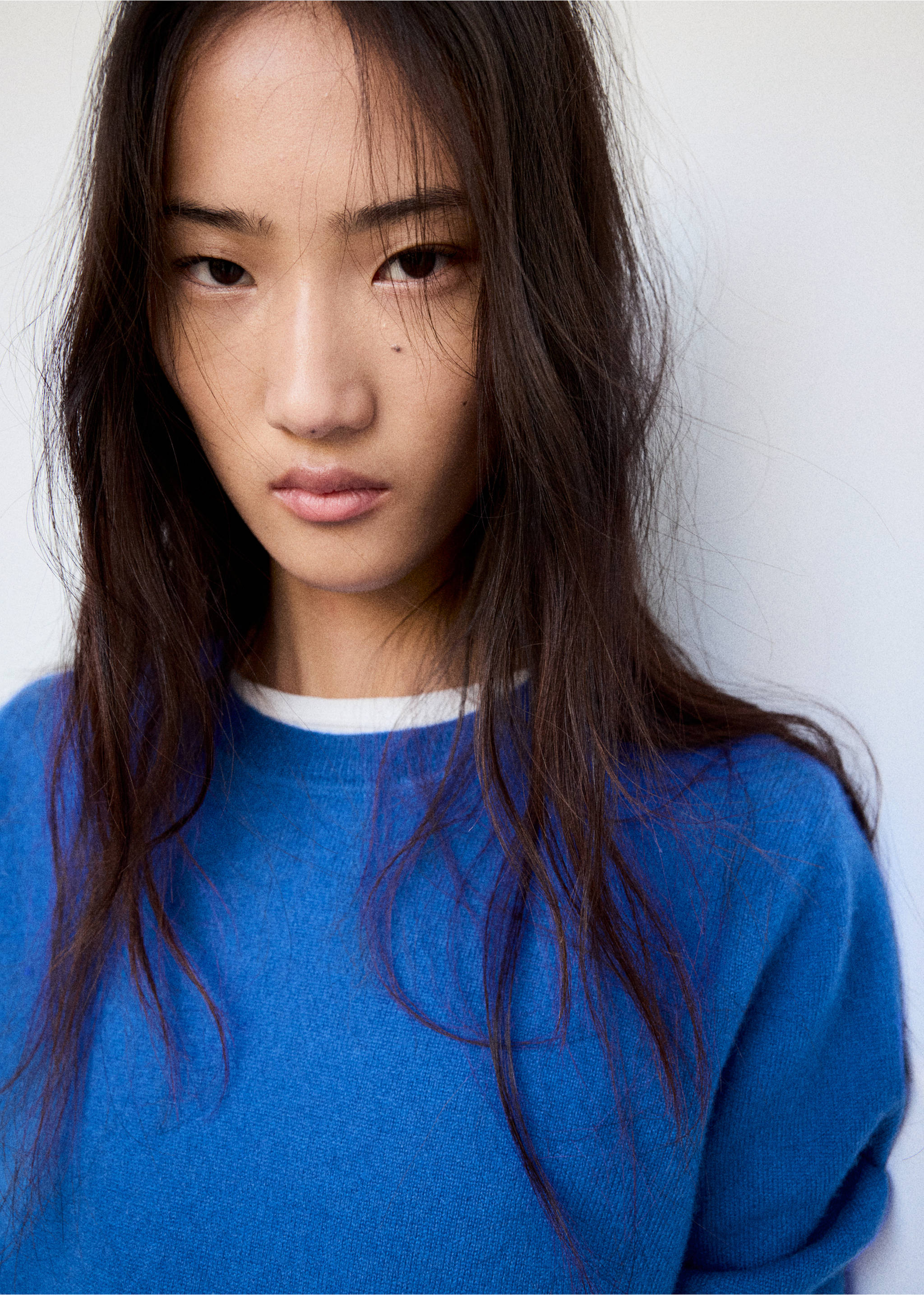 Close-up of a blue crew-neck jersey sweater with a white underlayer., Vibrant blue. Ref: 47031363-00.