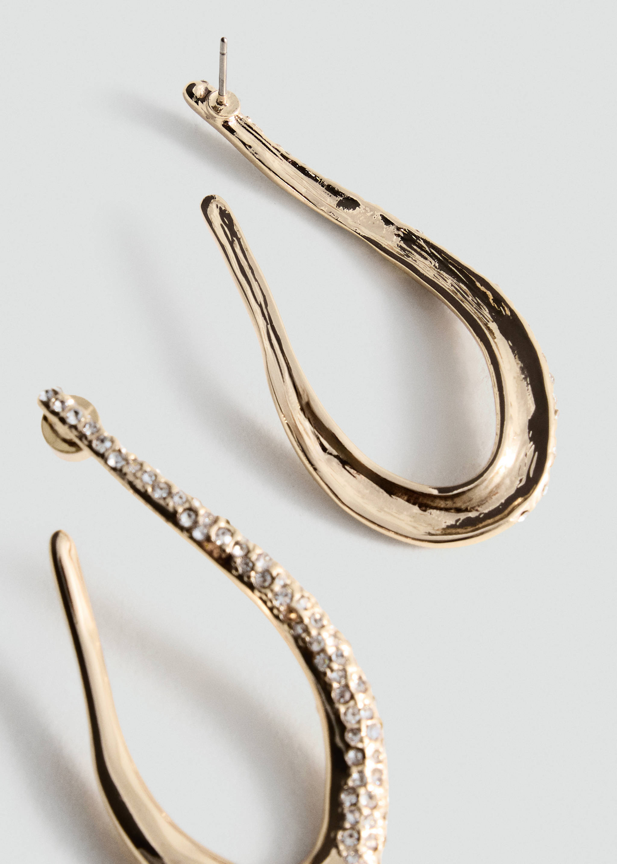 Gold-toned crystal-embellished teardrop earrings in close-up view