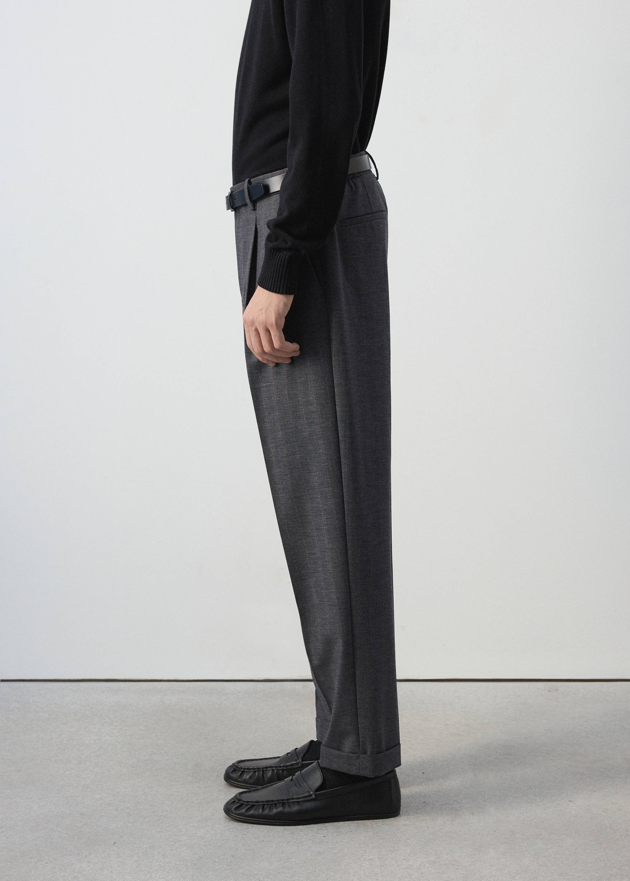 Pantalones de traje grises oscuros de corte recto con pinzas.