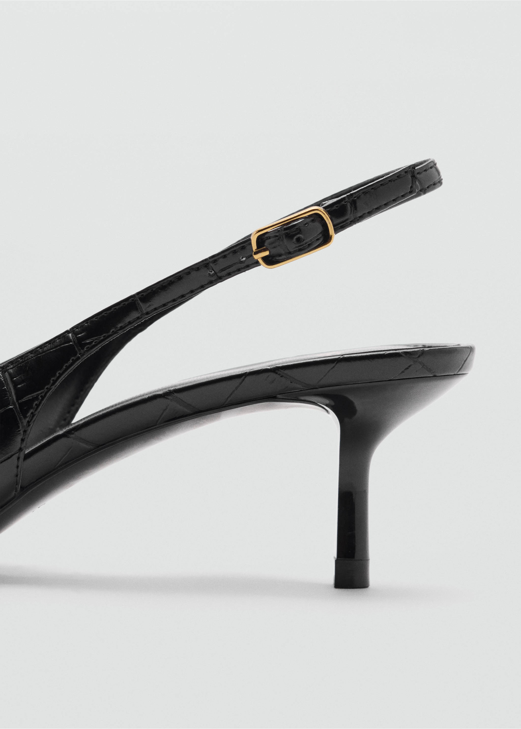 Black slingback shoe detail with a glossy embossed finish and a gold buckle., Black. Ref: 47041334-00.