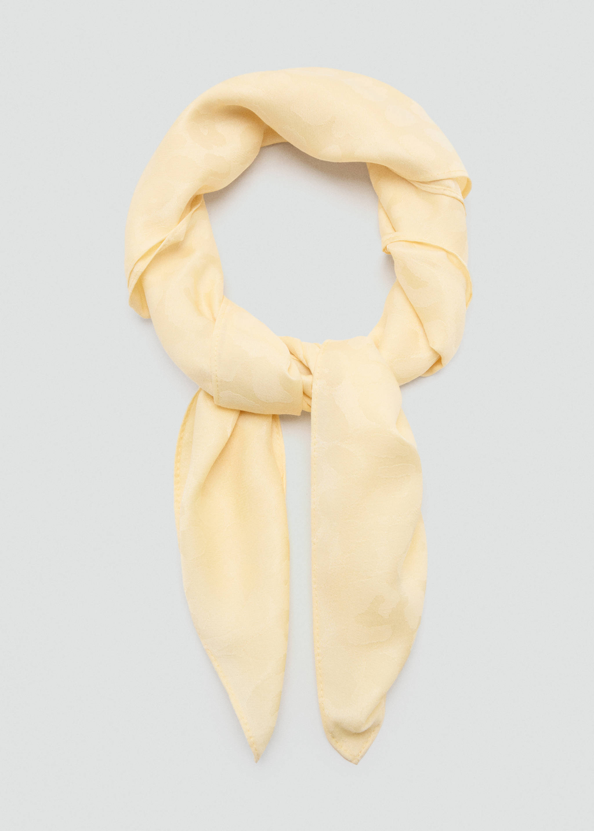 Light yellow scarf with a subtle tonal pattern, tied with dangling ends.