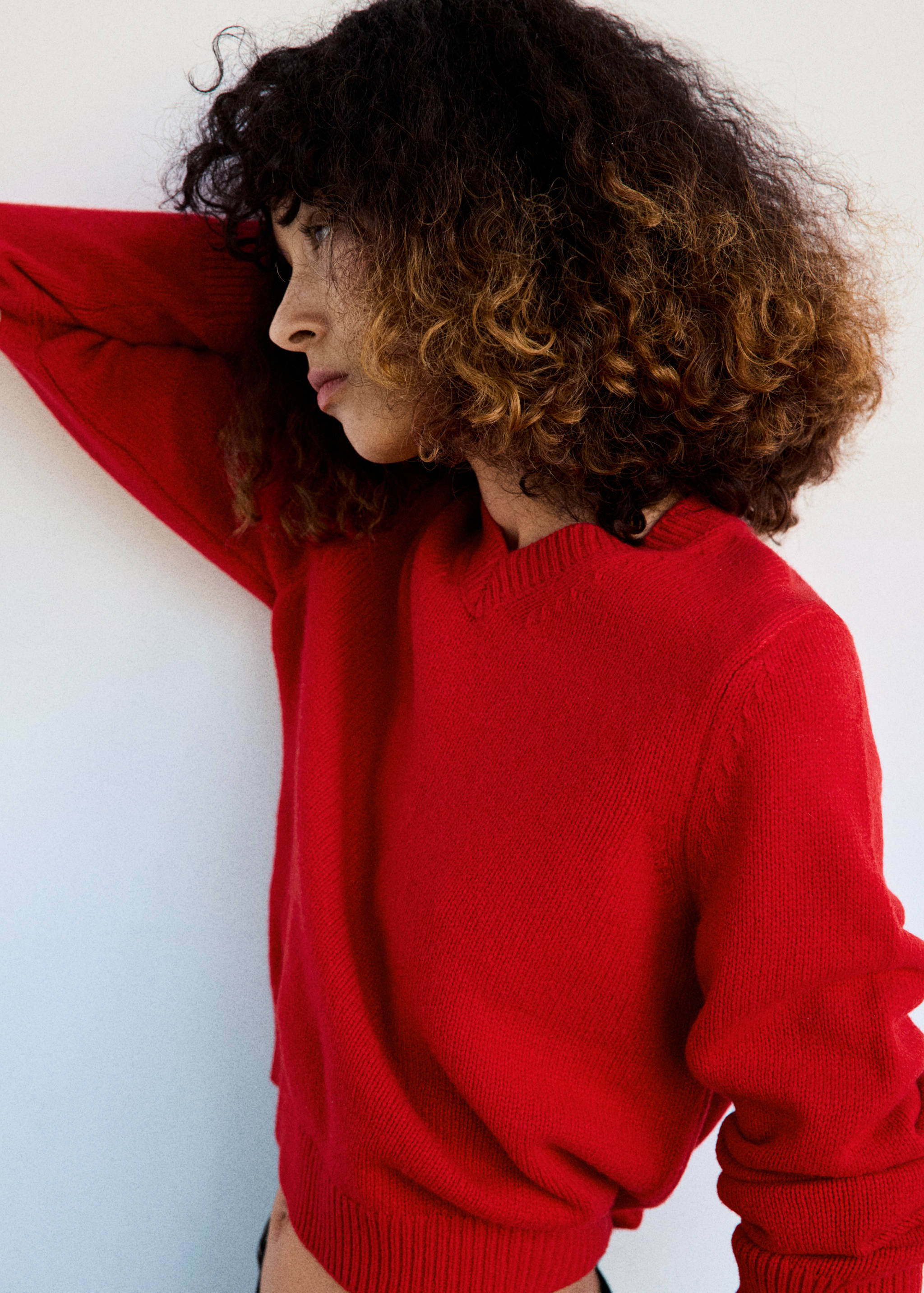 Close-up of a model wearing a red V-neck knit jersey.