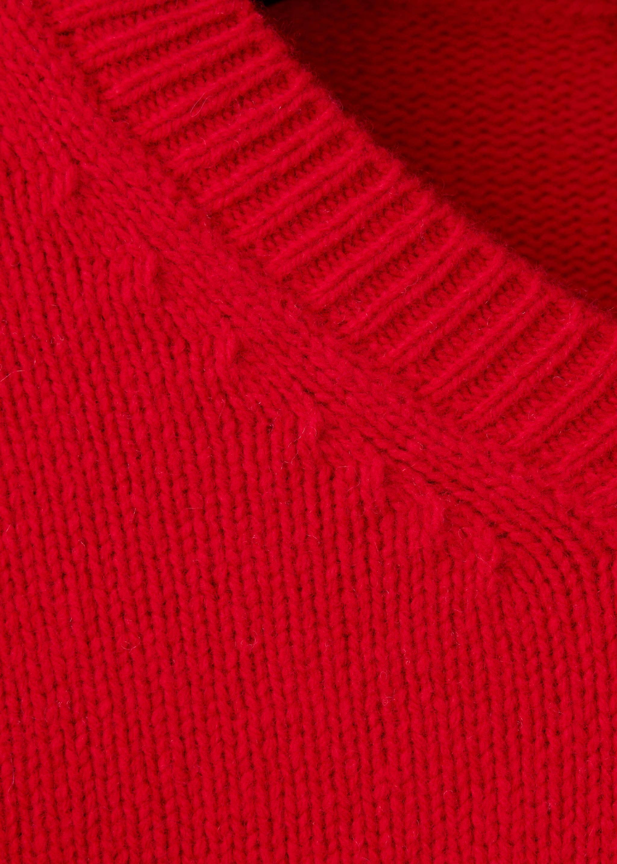 Close-up of the ribbed collar and knit texture on a red jumper.