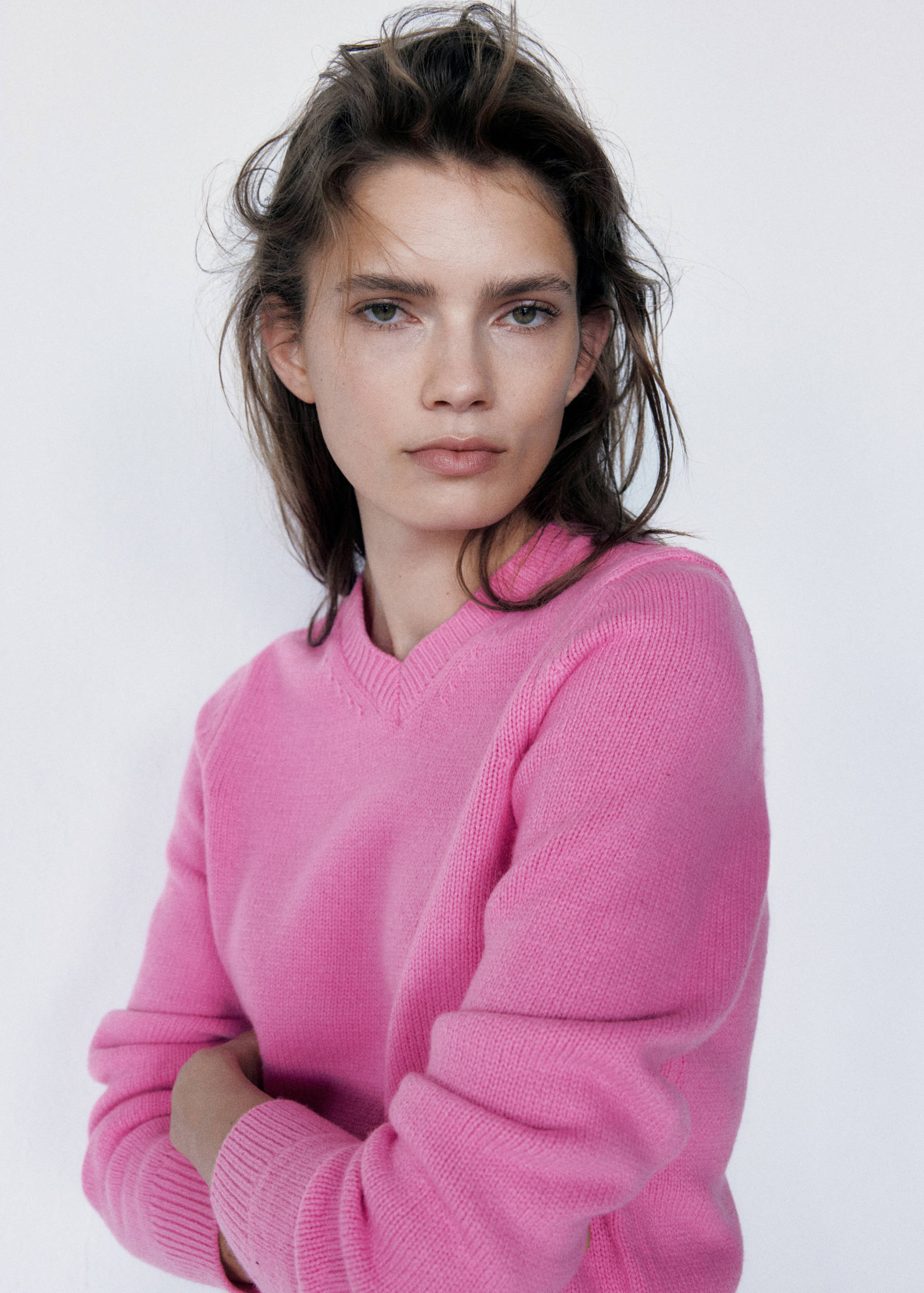 Pink knit jumper with a round ribbed neckline and long sleeves.