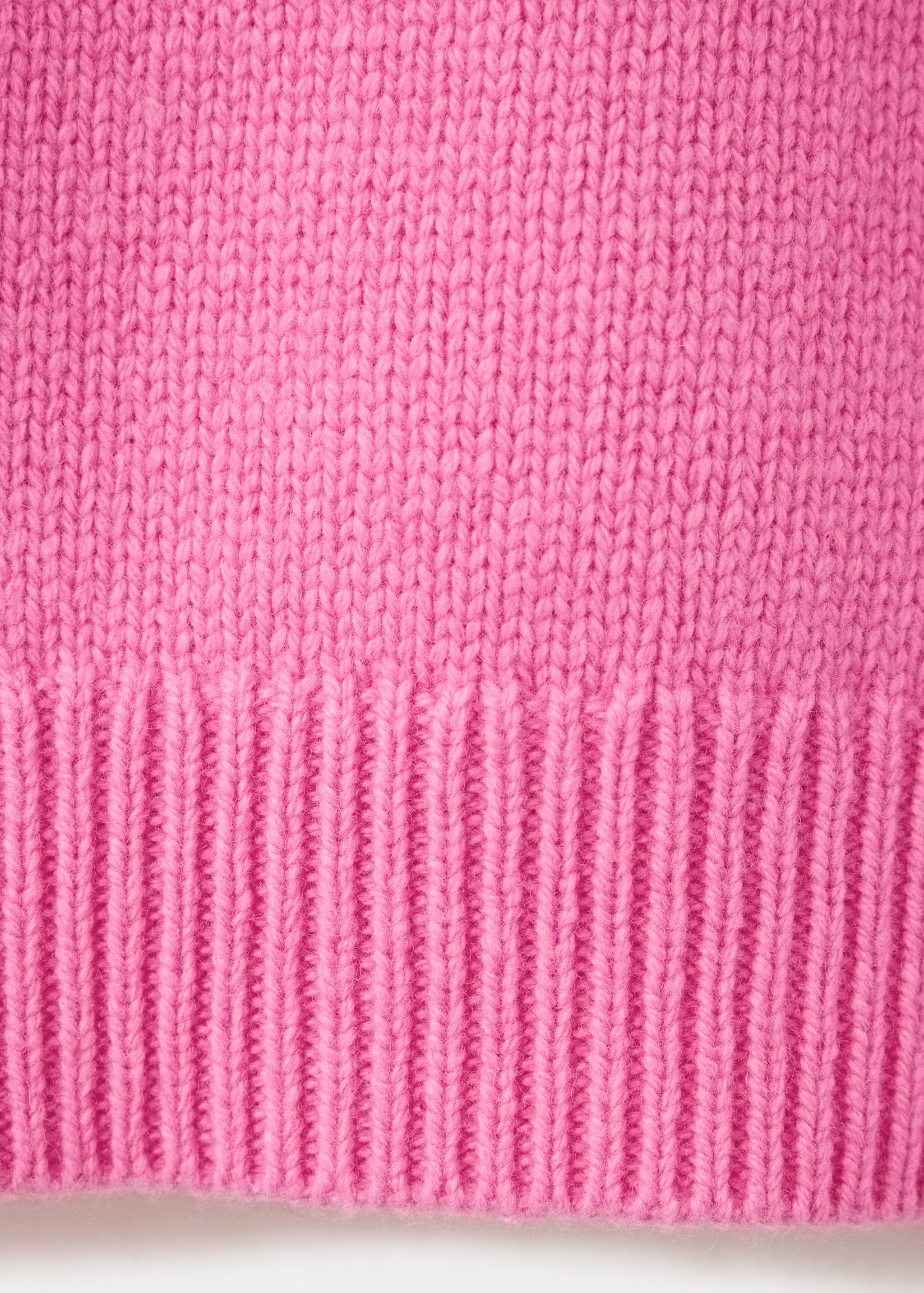 Pink jersey fabric detail showing knit texture and ribbed hem.