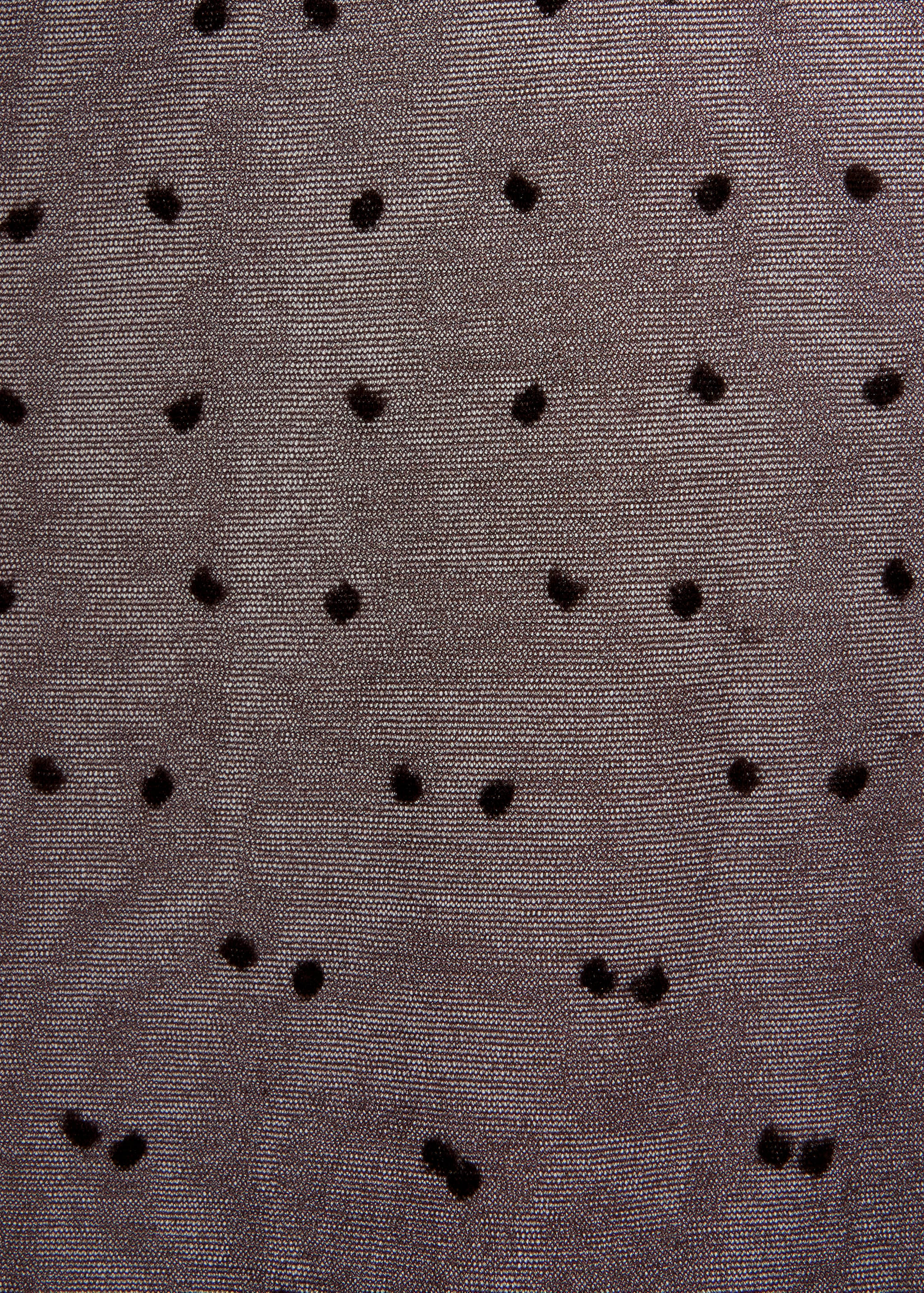 Close-up of dark sheer tights with a flocked plumeti dot pattern.