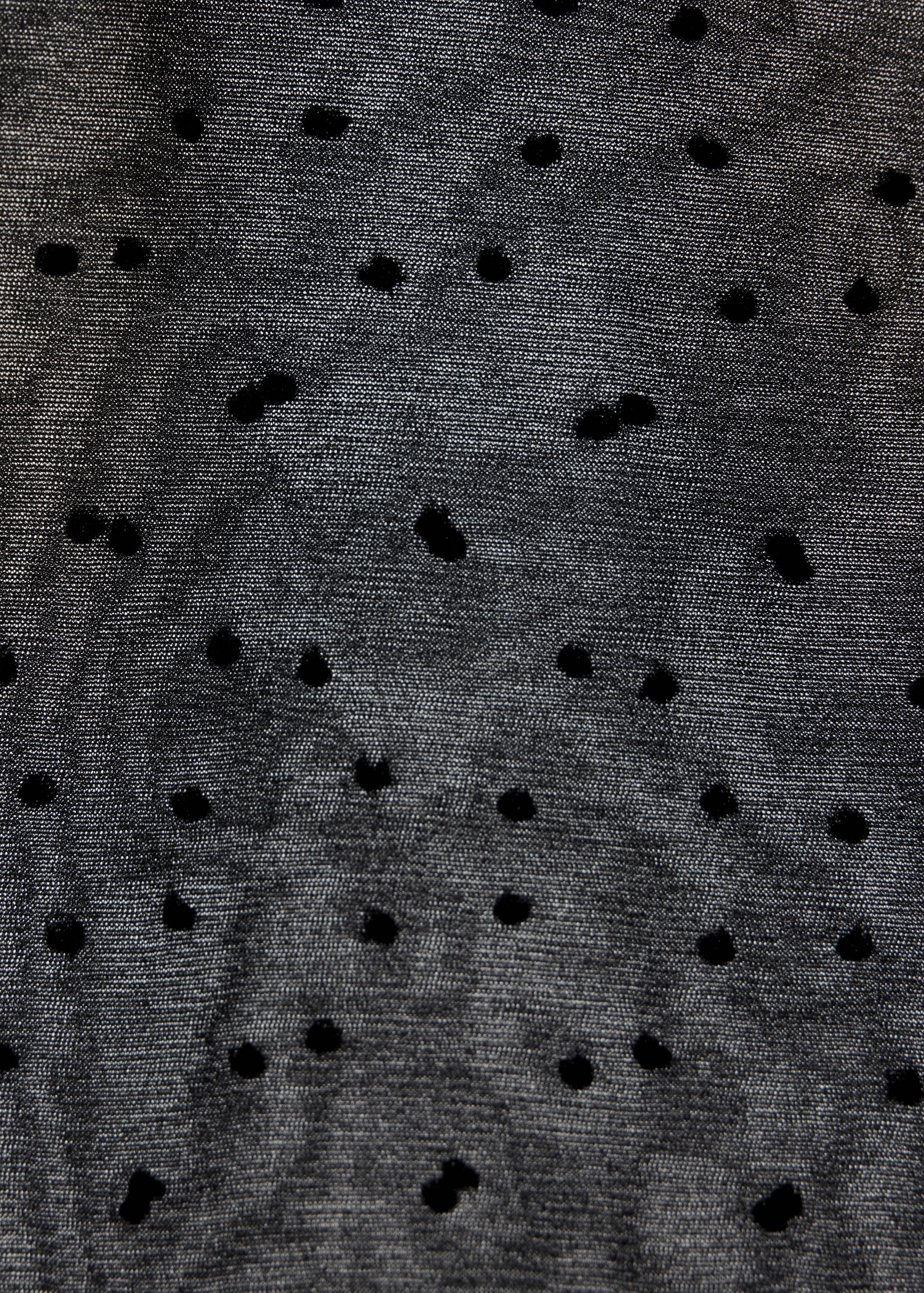 Close-up of sheer black tights with a polka-dot plumeti pattern.