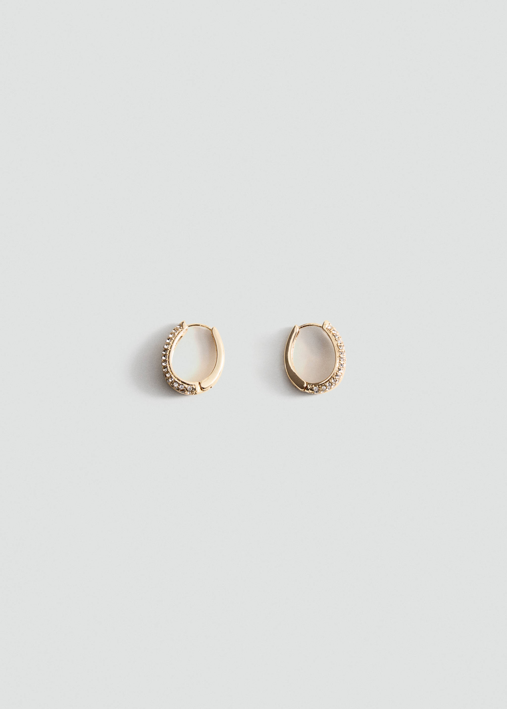 Pair of gold-toned rhinestone huggie hoop earrings.