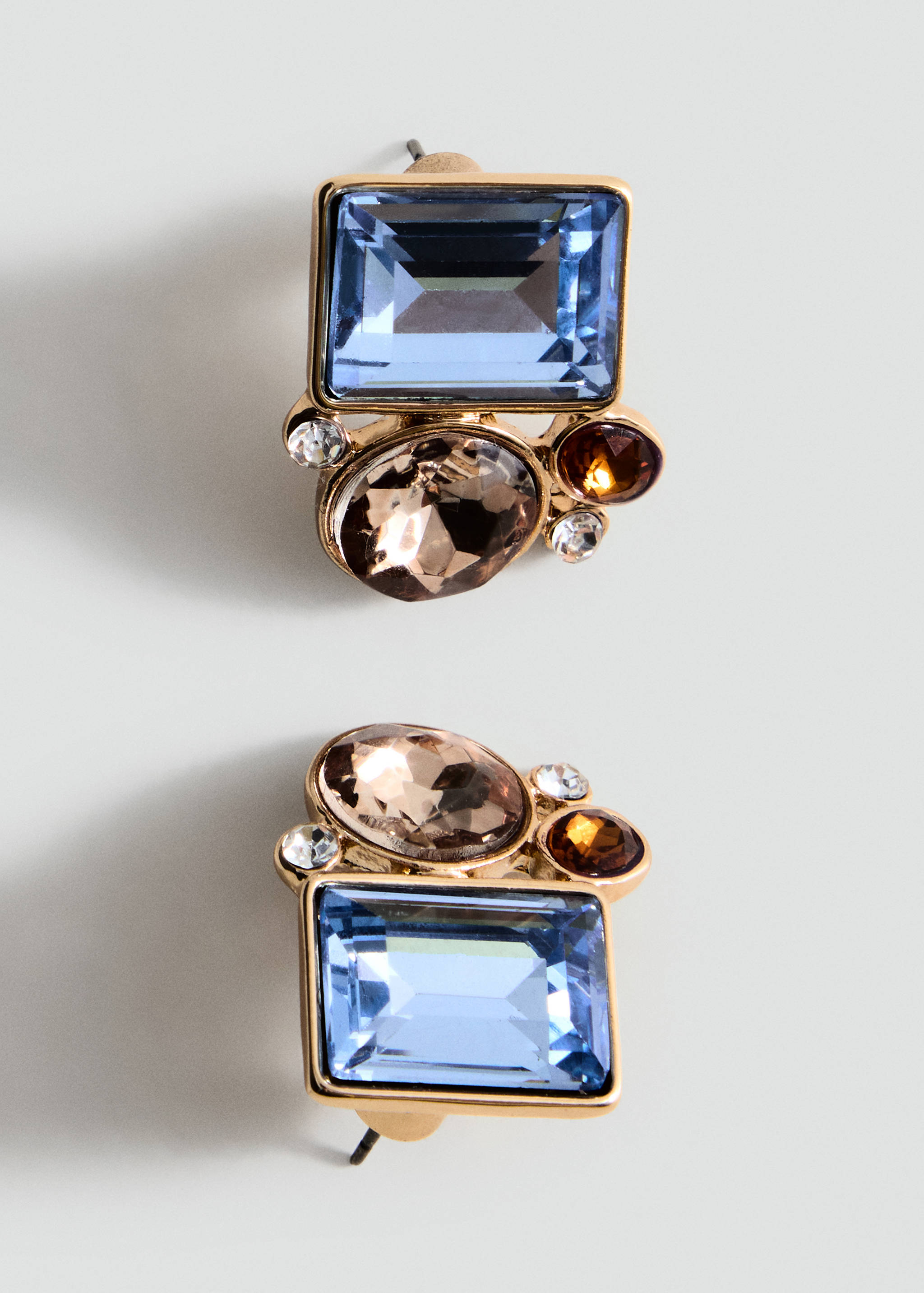 Gold-tone crystal stud earrings with pale blue and brown stones.