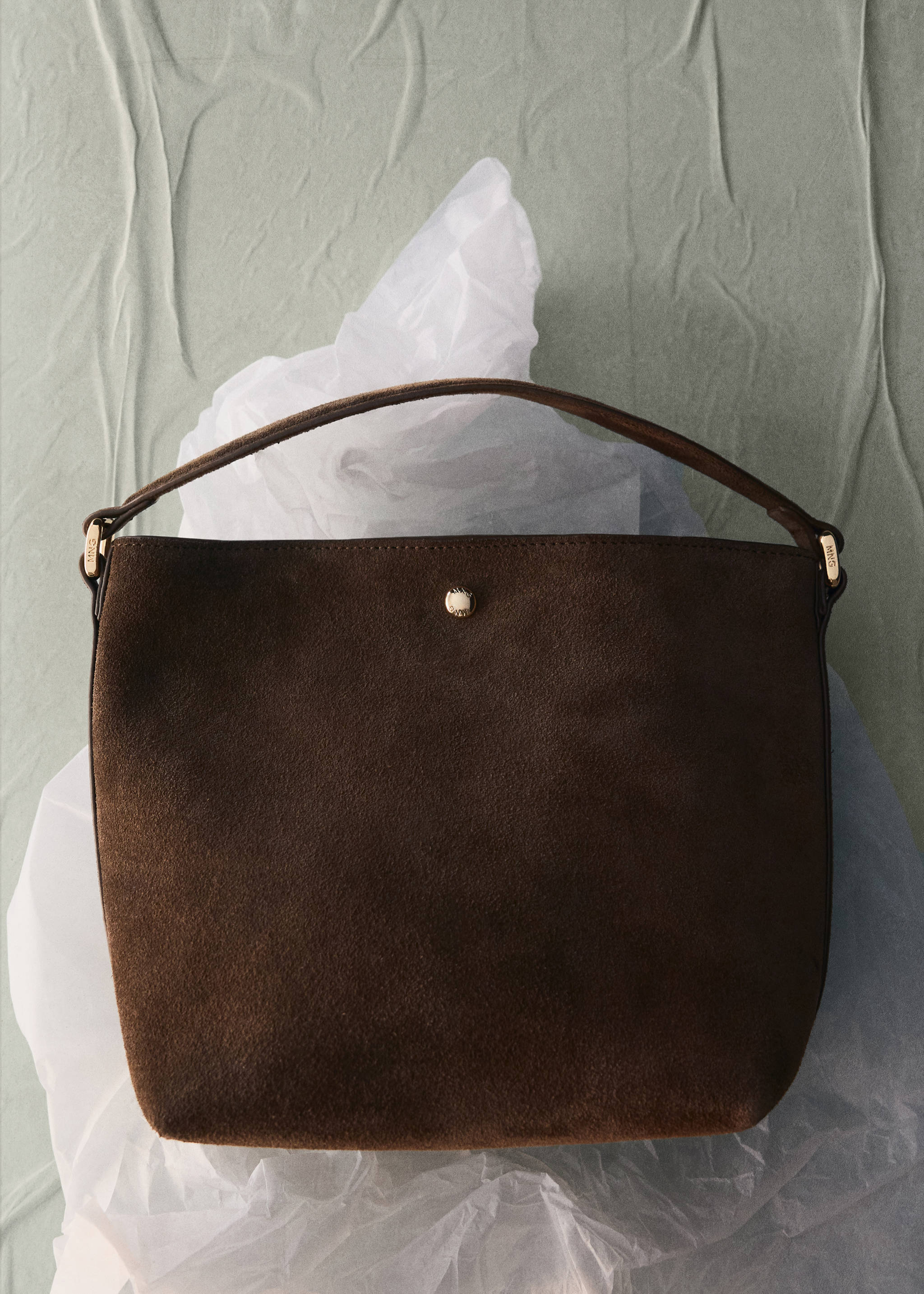 Dark brown suede bucket bag with a top handle and metallic hardware.