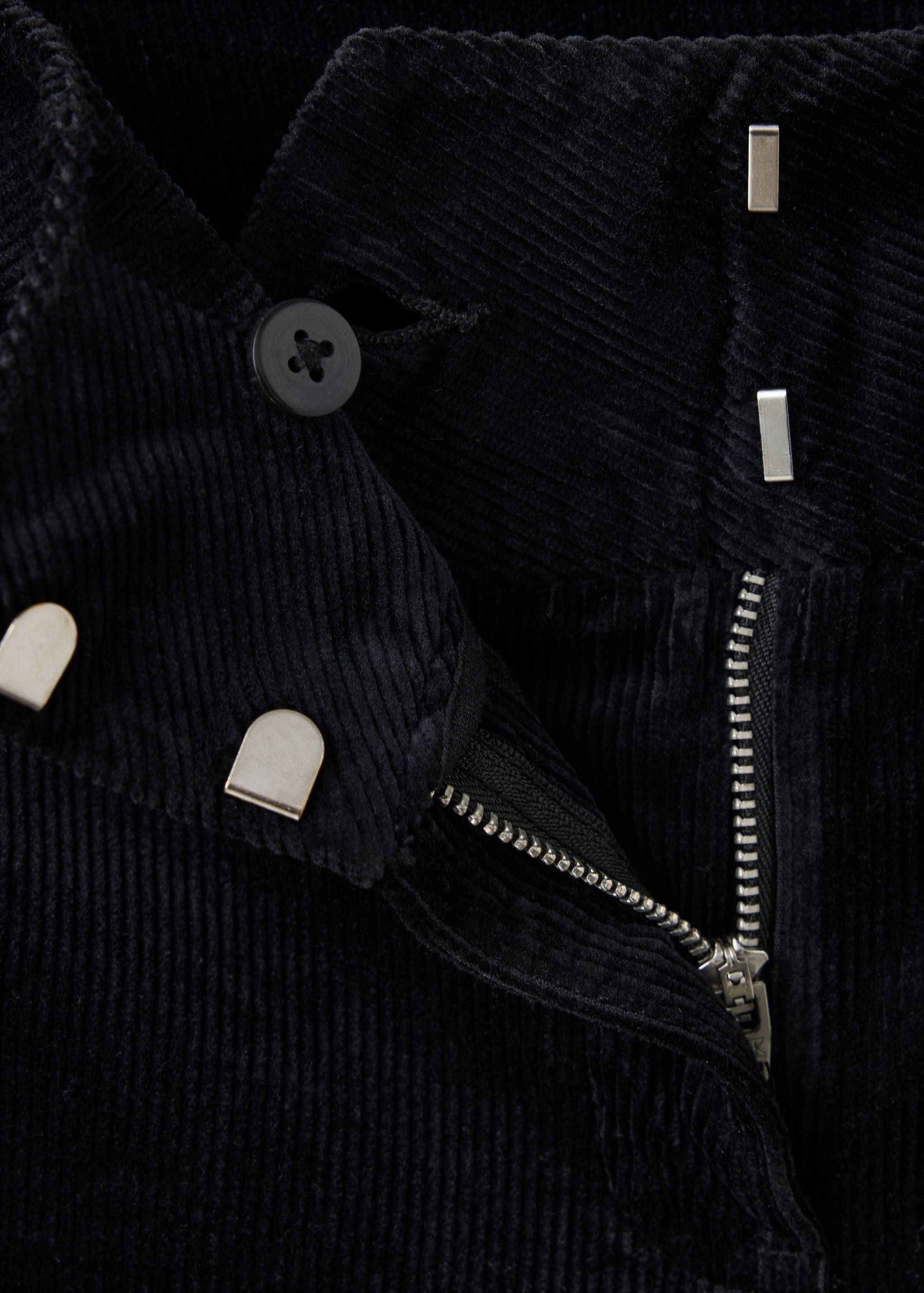 Black corduroy trousers detail of waistband, zip and button fastening