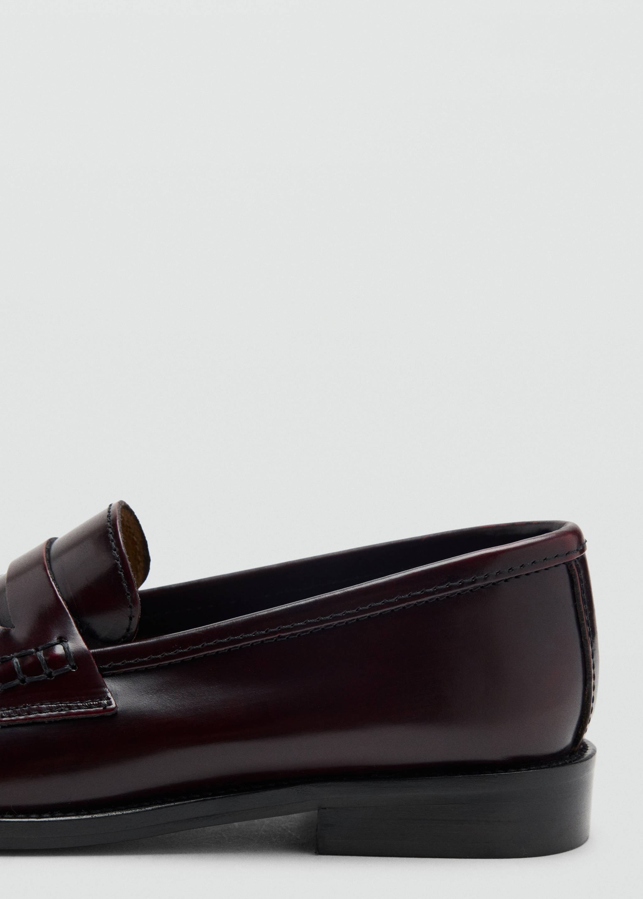 Burgundy leather penny loafer detail, showing side and heel construction.