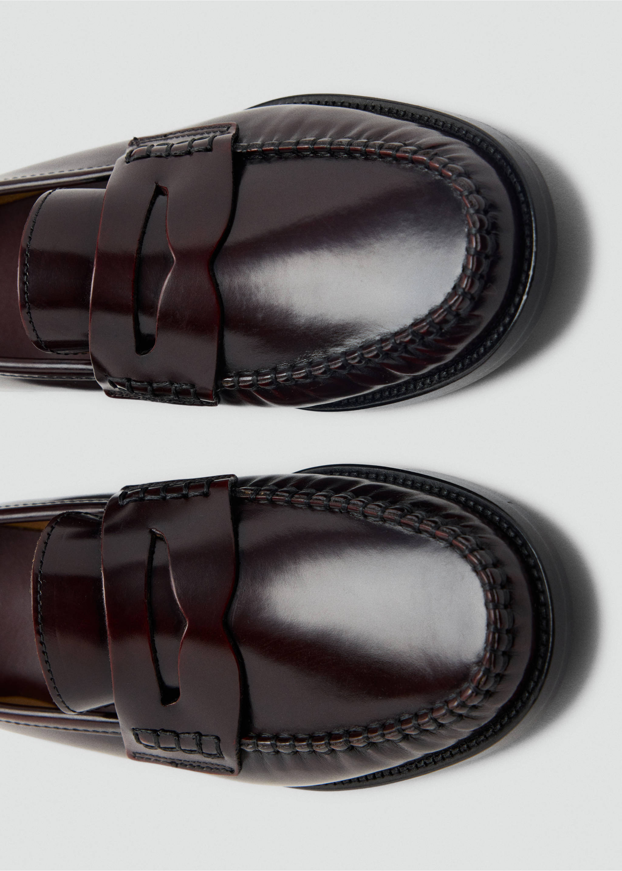 Close-up of burgundy leather penny loafers with polished finish and moc-toe stitching., Burgundy. Ref: 47061331-00.