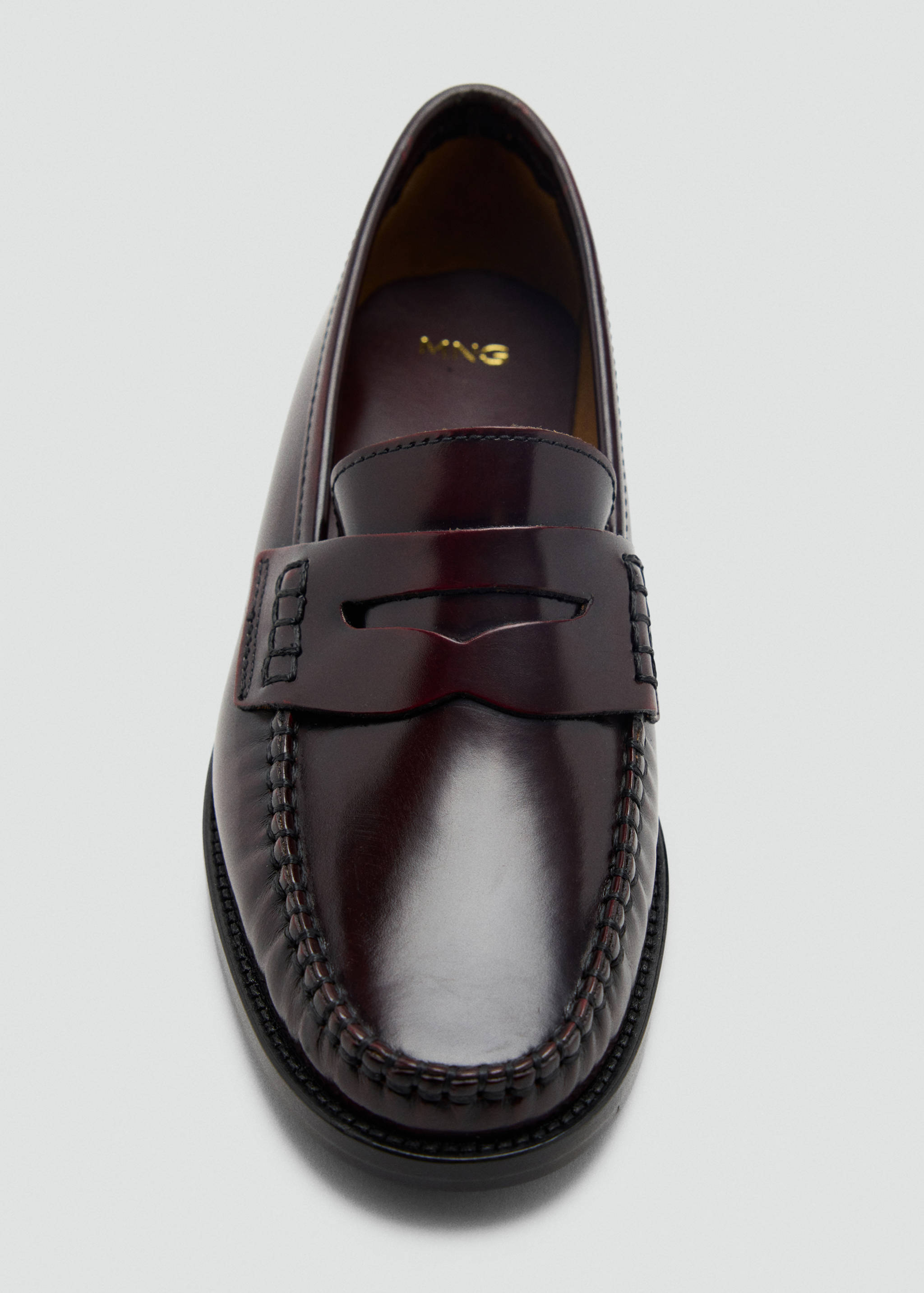 Burgundy leather penny loafer with a polished finish and moc toe detail.