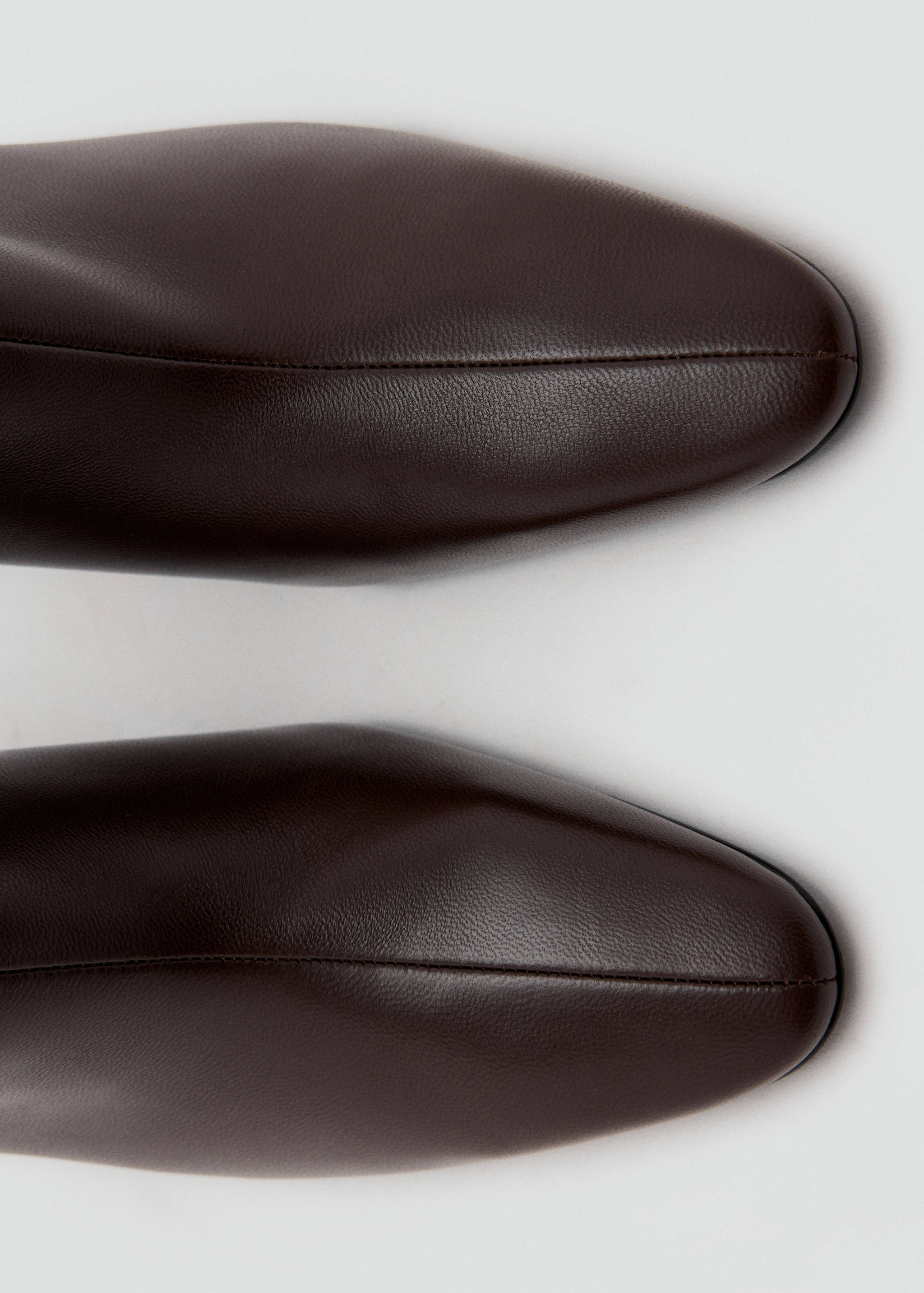 Close-up of dark brown pointed-toe ankle boots.