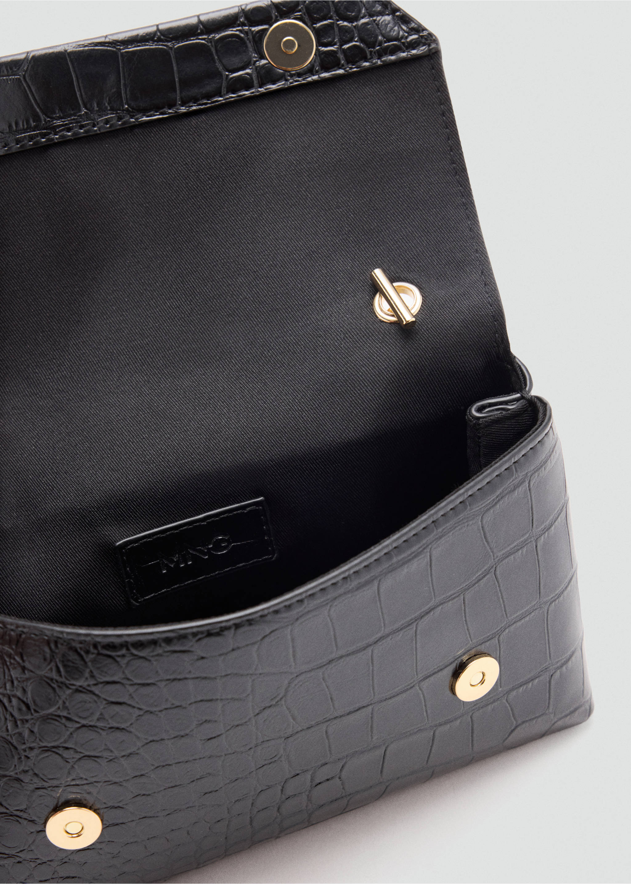 Close-up of the interior of a black crocodile-embossed cross-body bag with gold-coloured hardware., Black. Ref: 47061341-00.