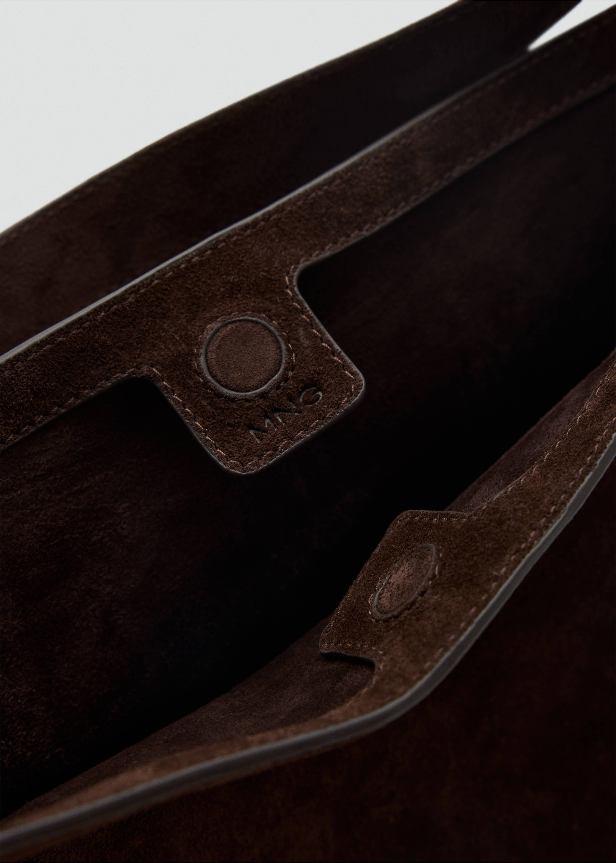 Close-up of the magnetic closure detail inside a dark brown suede bucket bag., Chocolate. Ref: 47061342-00.