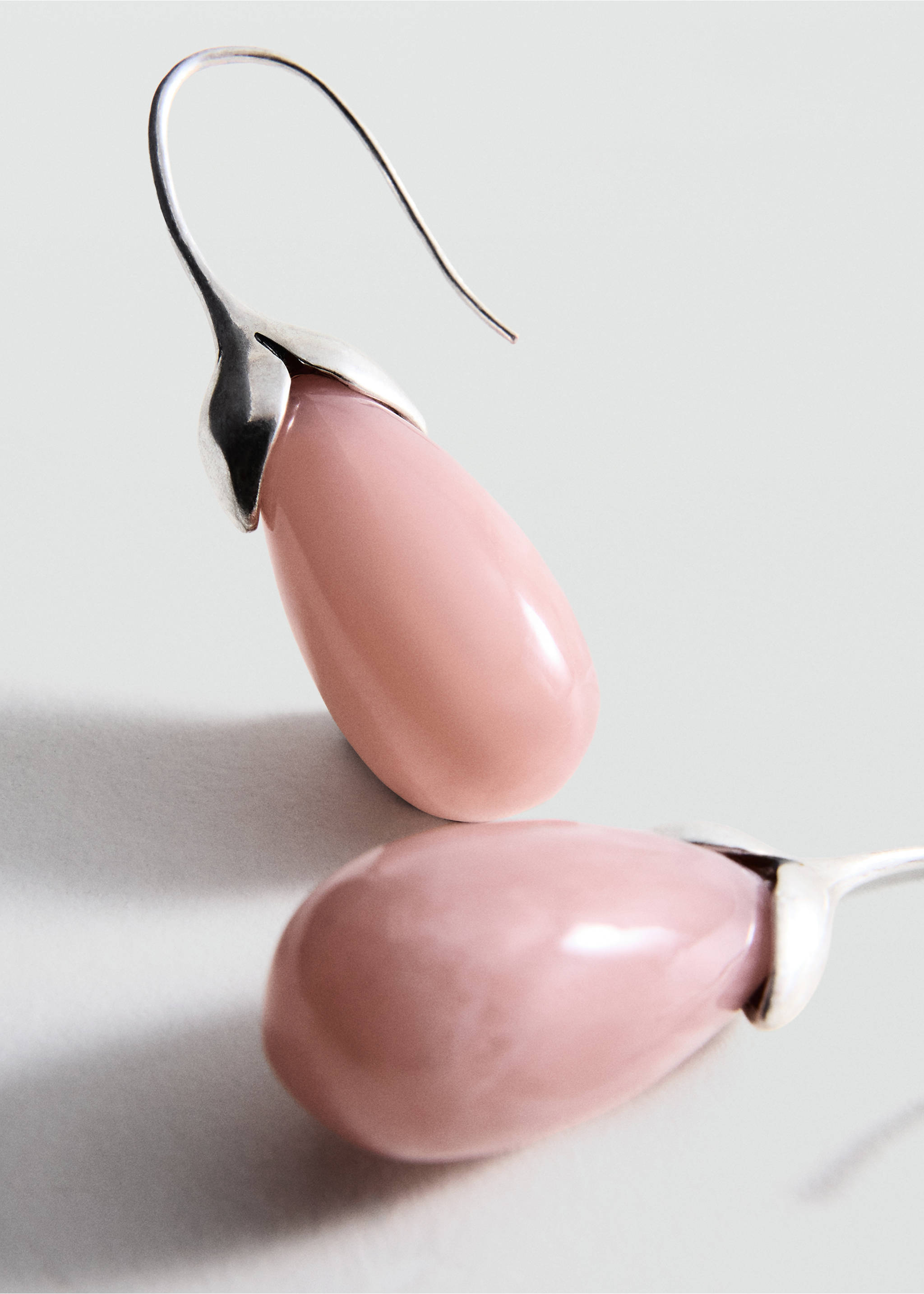 Close-up of pink teardrop stone earrings with silver-coloured hooks., Silver. Ref: 47061383-00.