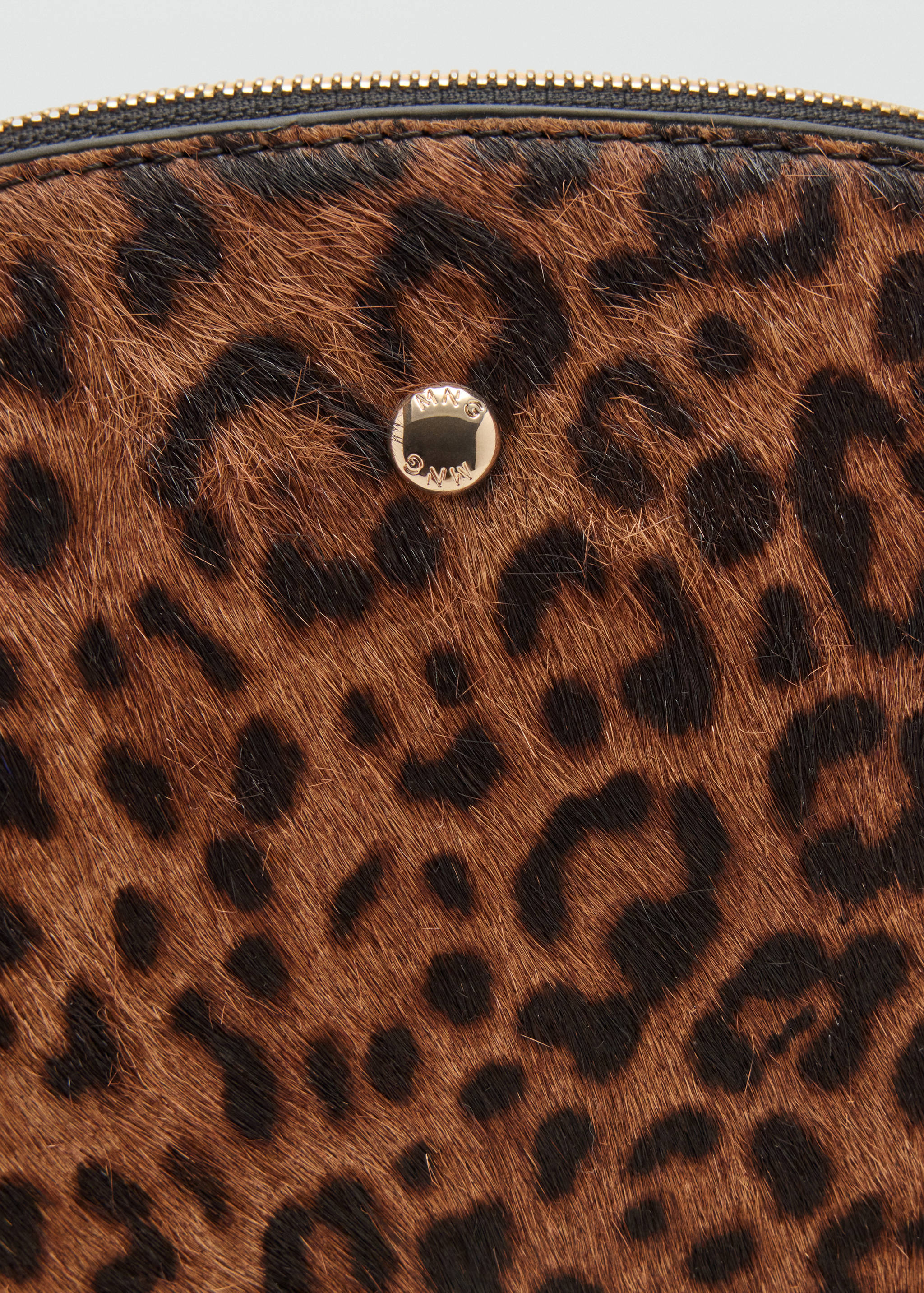 Close-up of a leopard-print make-up bag with a gold zip and logo detail.