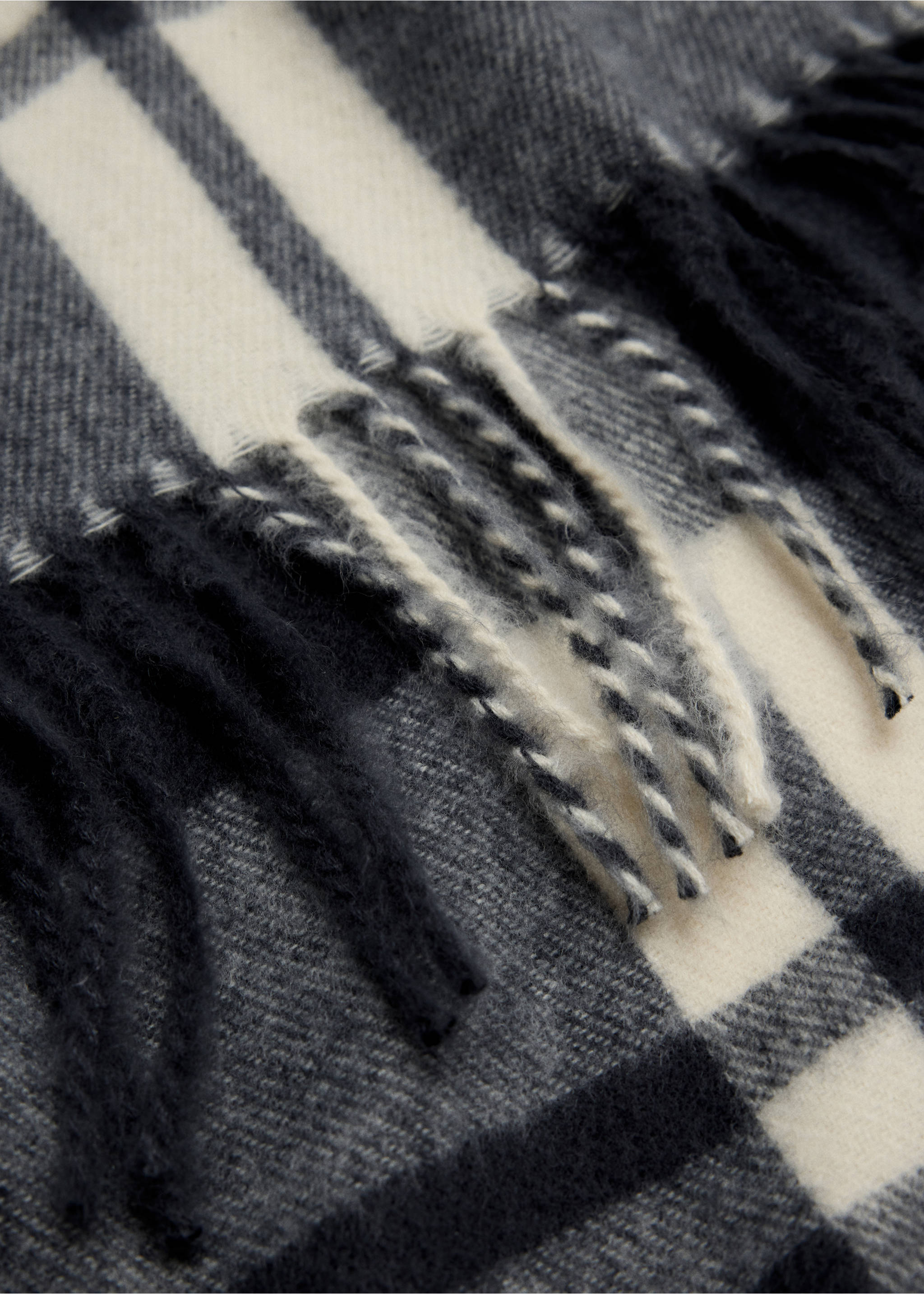 Close-up of a black, grey and off-white check scarf with fringed edges., Navy. Ref: 47061408-00.