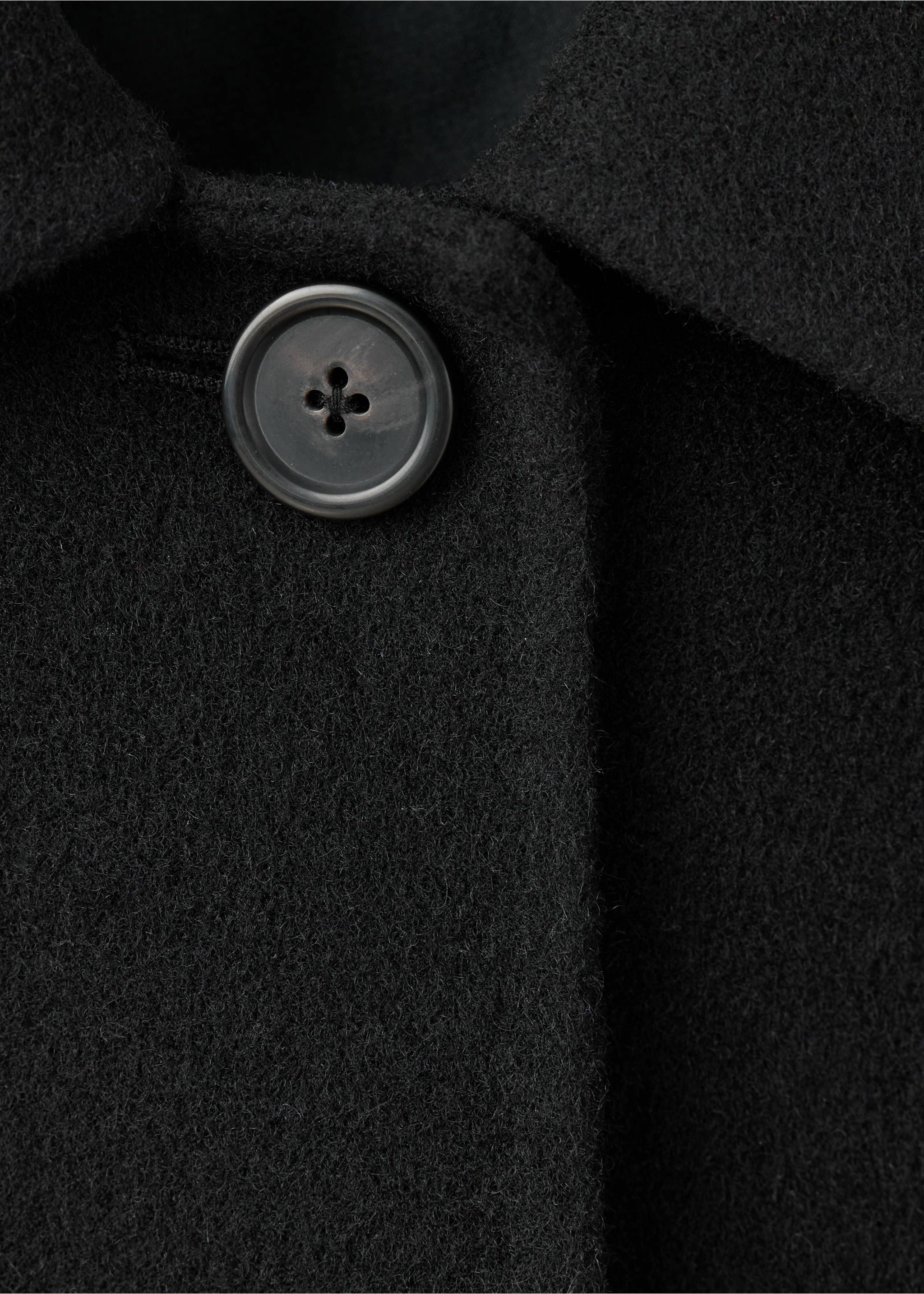 Close-up of a black coat showing the collar and button detail., Black. Ref: 47061446-00.