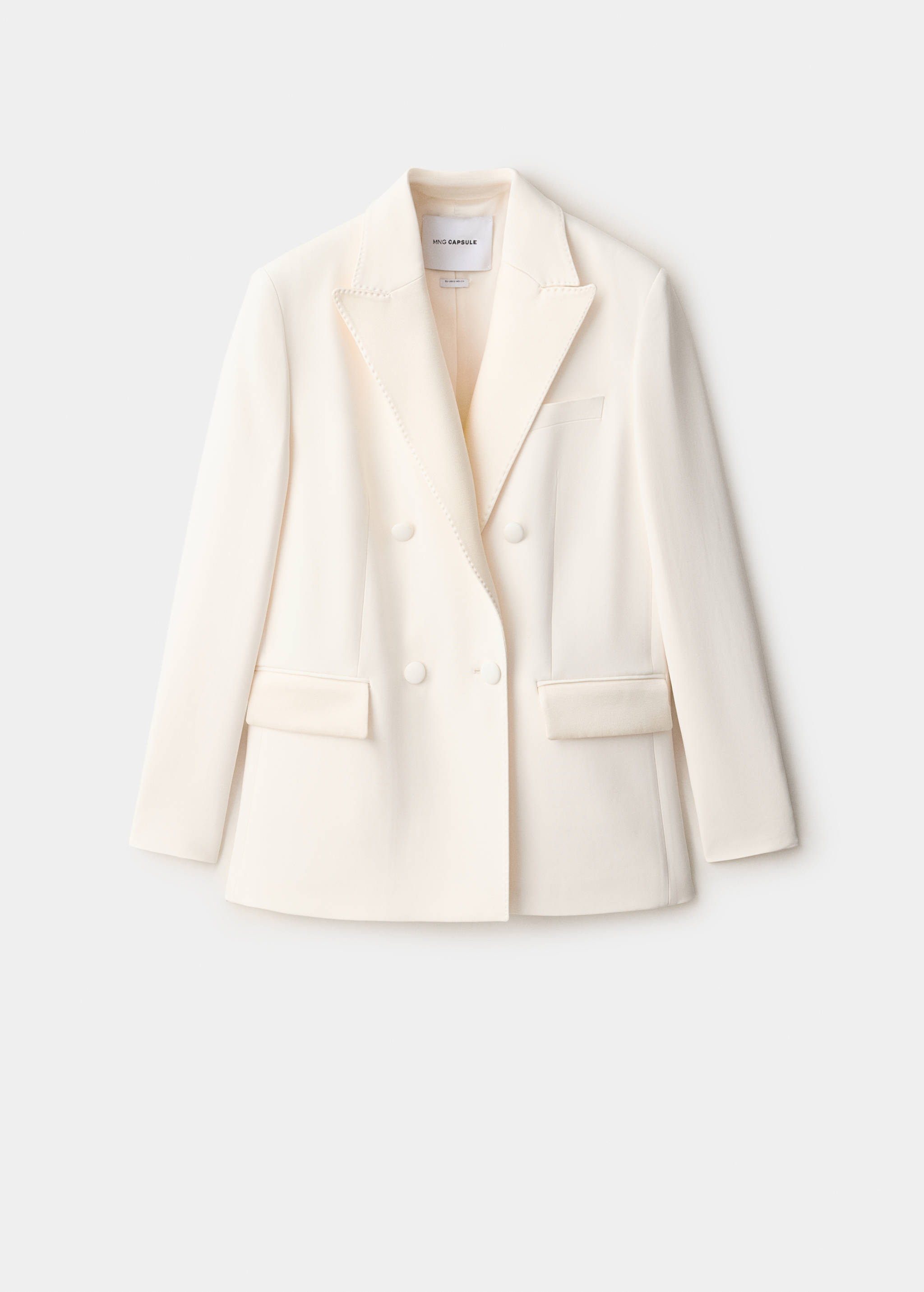 Cream double-breasted blazer with peak lapels and covered buttons.