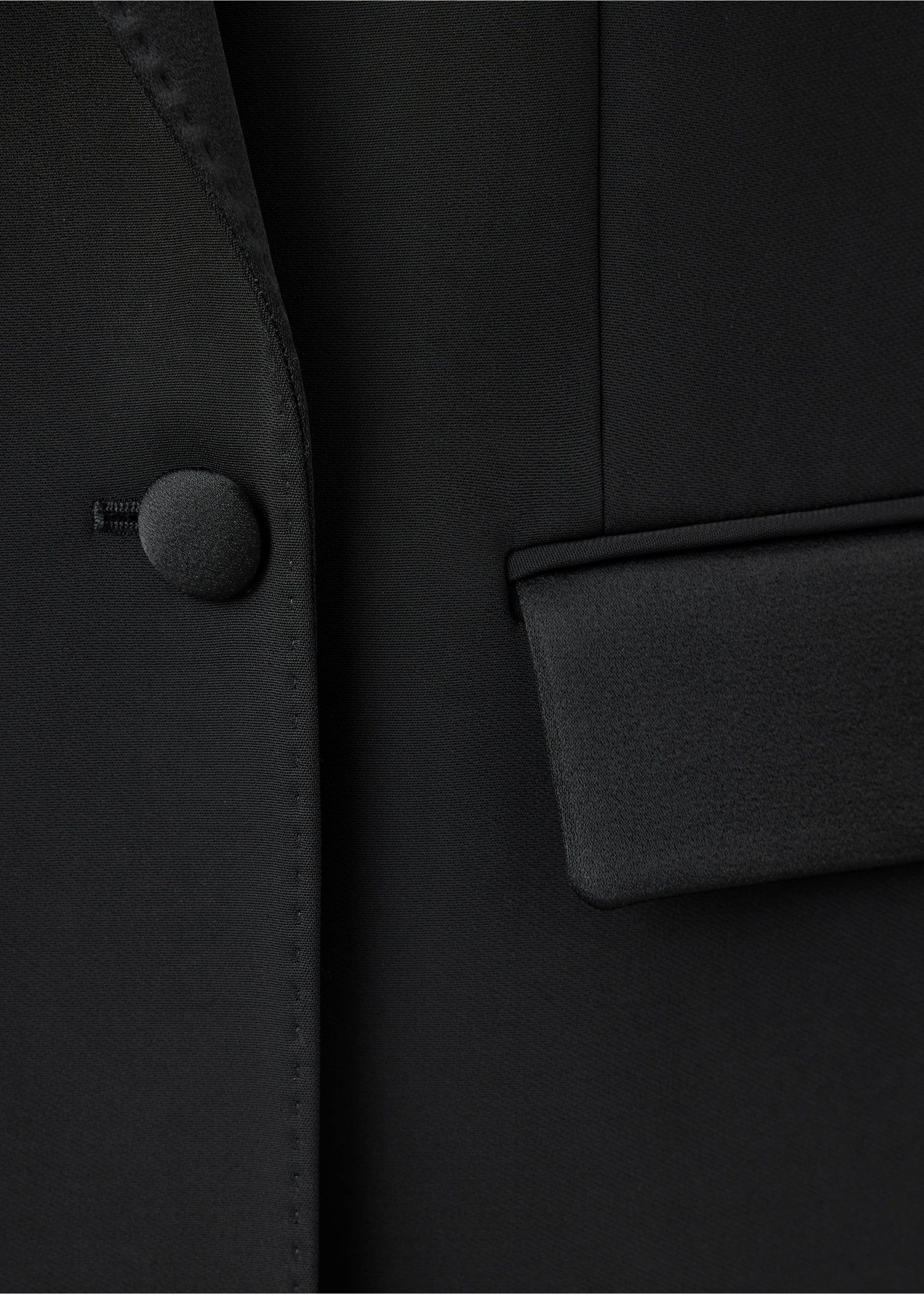 Black blazer detail with a satin button and pocket flap., Black. Ref: 47061470-00.